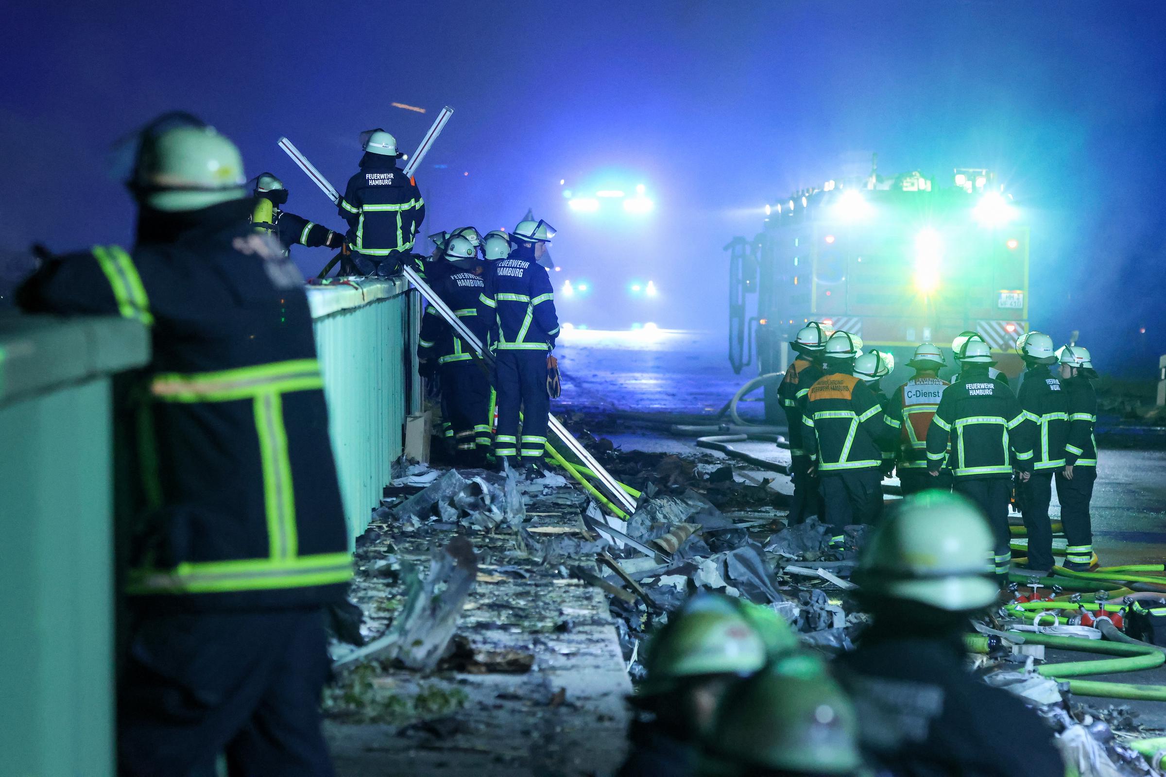 25. August 2025, Hamburg: Feuerwehrleute löschen einen Brand in einem Industriegebiet im Hamburger Hafen. Nach dem Ausbruch eines Feuers in einem Lagerhaus in einem Industriegebiet in Hamburg kam es zu mehreren Explosionen | Quelle: Getty Images