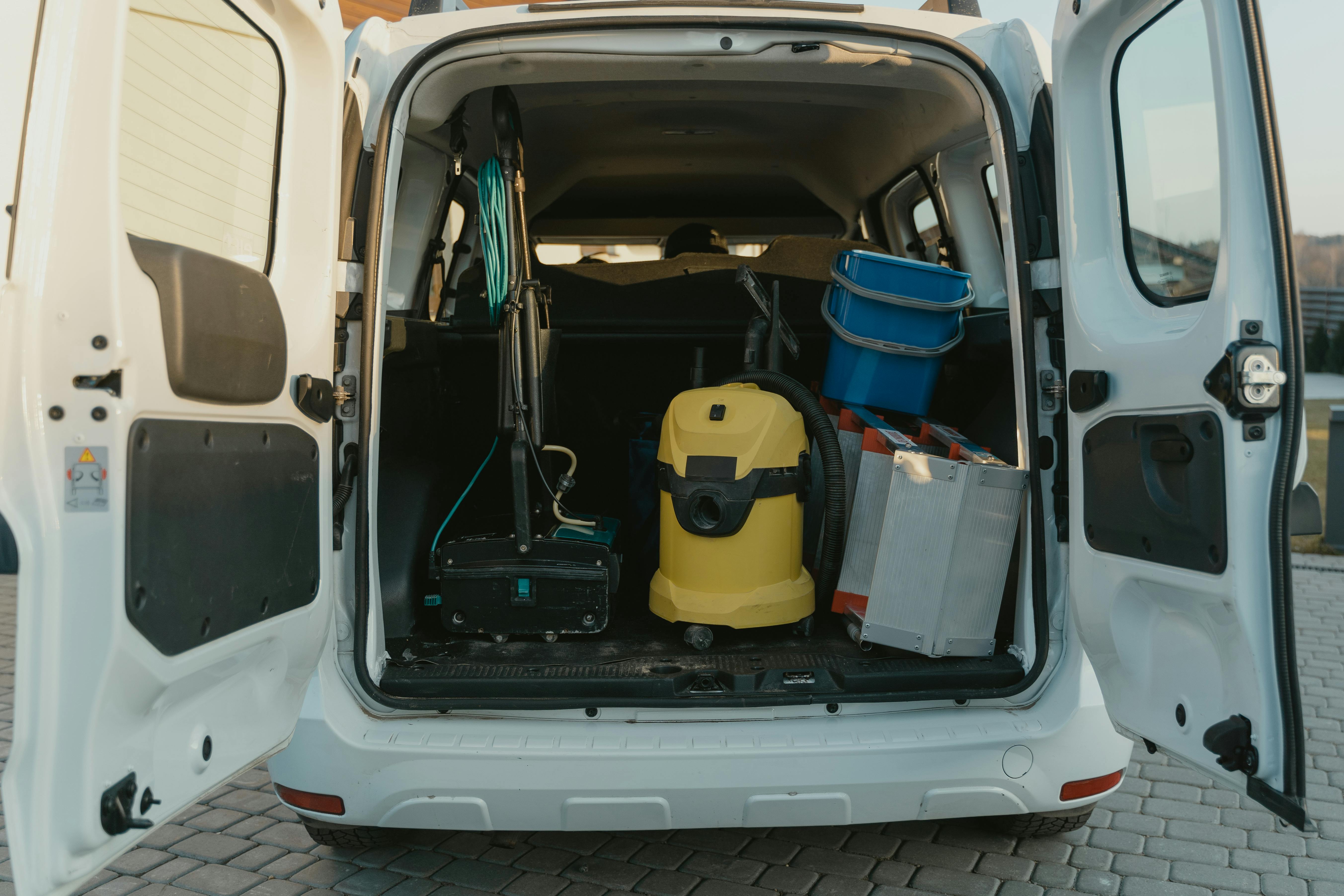 Ein weißer Lieferwagen mit Reinigungsgeräten | Quelle: Pexels