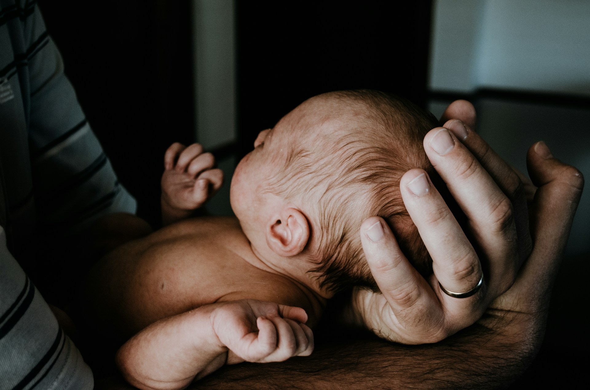 Ein Mann hält sein neugeborenes Baby | Quelle: Unsplash
