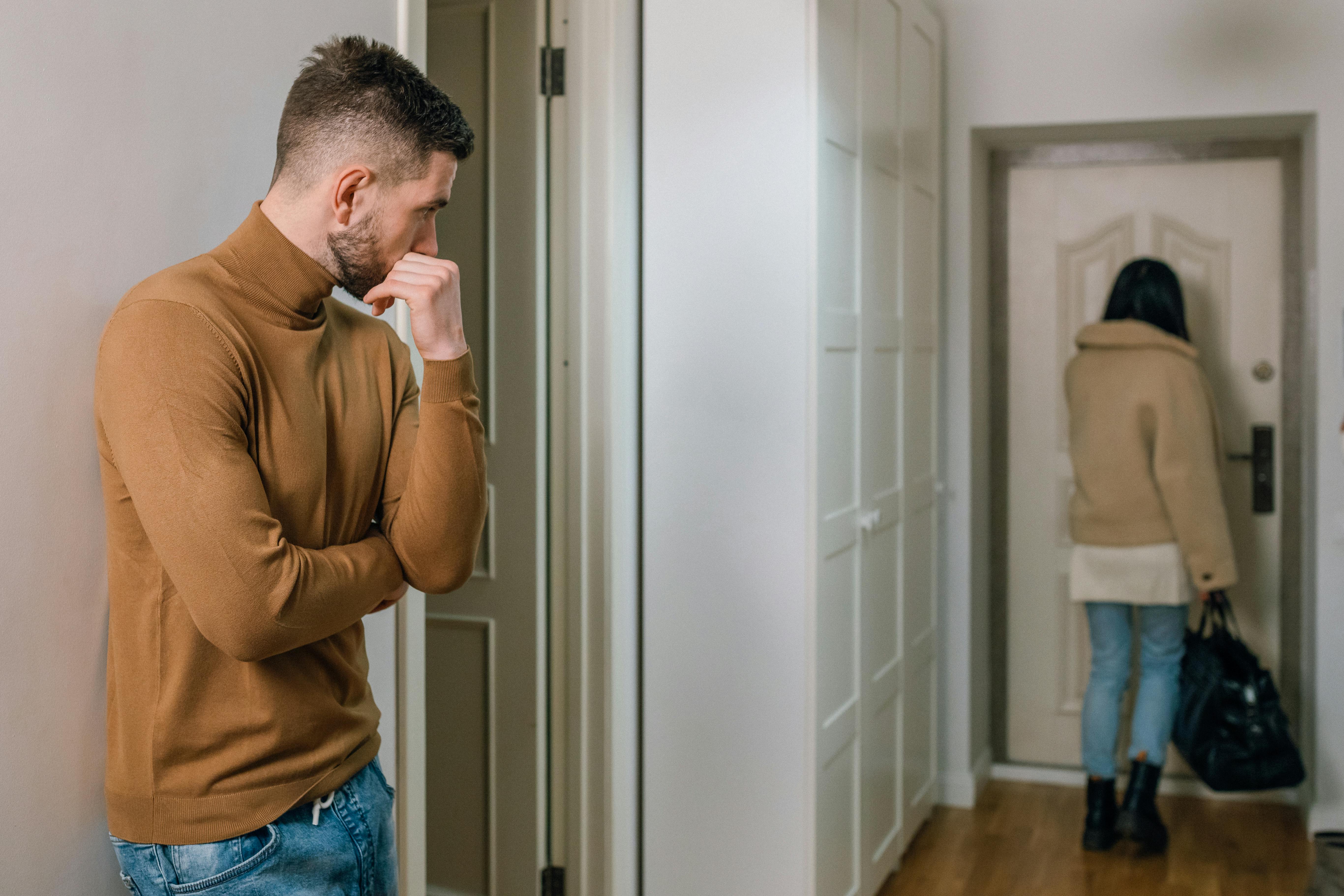 Mann schaut einer Frau nach, die aus der Wohnung geht | Quelle:Pexels