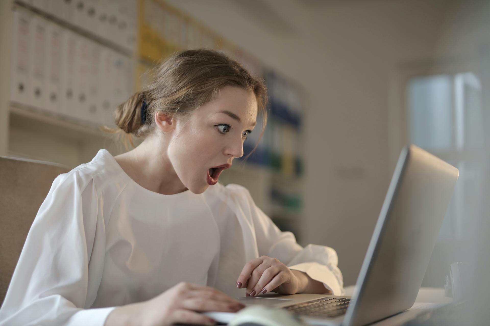 Eine Frau, die schockiert auf etwas auf einem Laptop reagiert | Quelle: Pexels