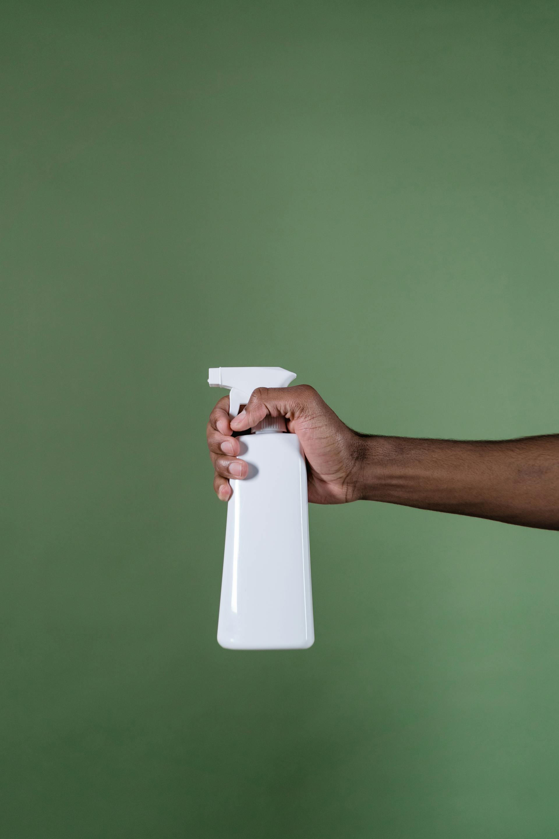 Ein Mann hält eine Sprühflasche | Quelle: Pexels