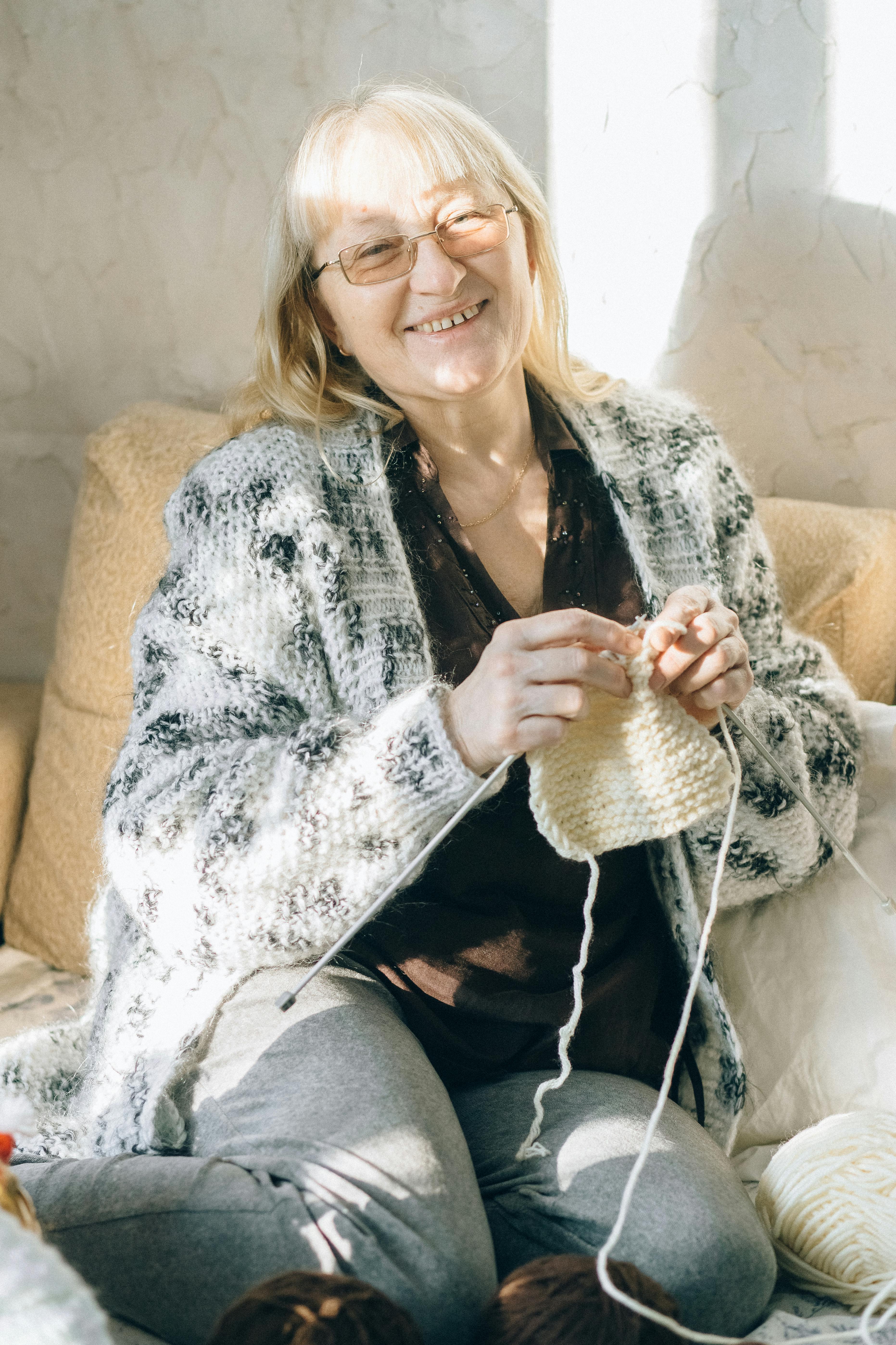Eine glückliche Frau beim Stricken | Quelle: Pexels