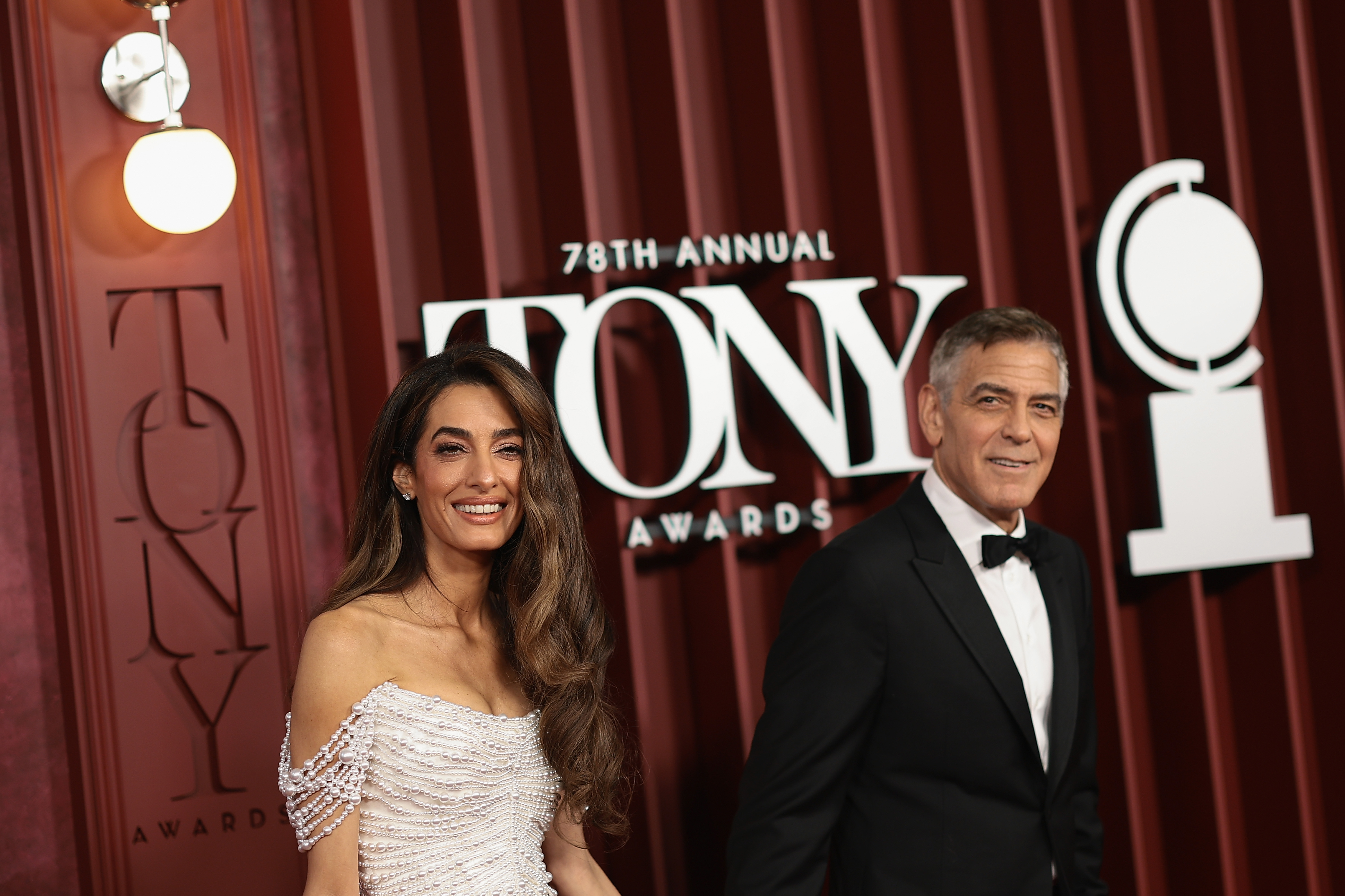 George und Amal Clooney lächeln Seite an Seite und posieren neben dem Schild der 78th Tony Awards. Die selbstbewusste Präsenz des Paares verleiht der großen Nacht am Broadway einen Hauch von Hollywood-Charme.