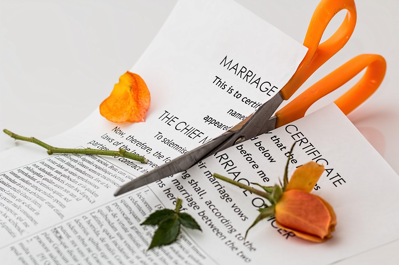 Eine Schere, die eine Heiratsurkunde durchschneidet | Quelle: Pixabay