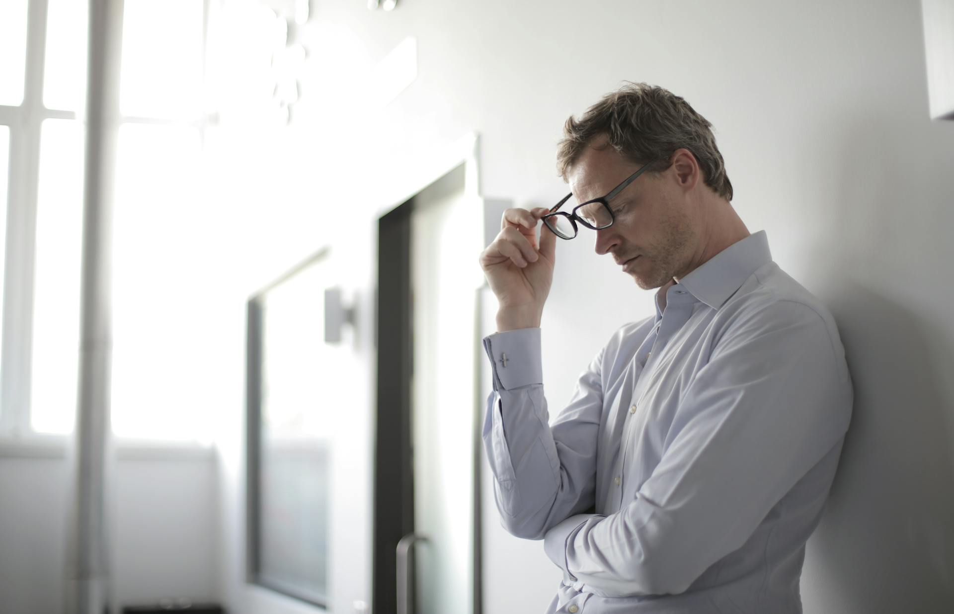 Ein Mann nimmt seine Brille ab | Quelle: Pexels