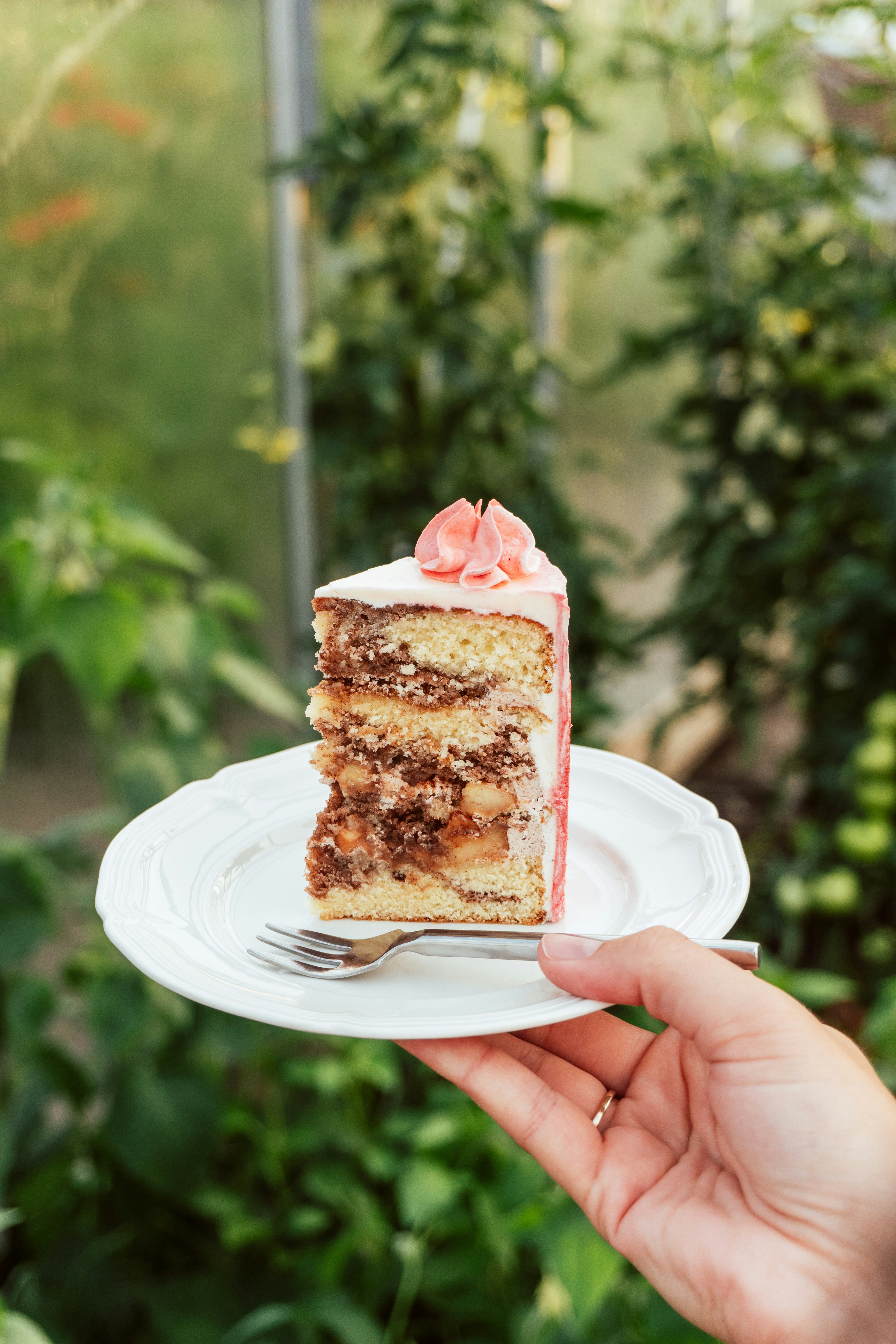 Eine Person hält ein Stück Kuchen in der Hand | Quelle: Unsplash
