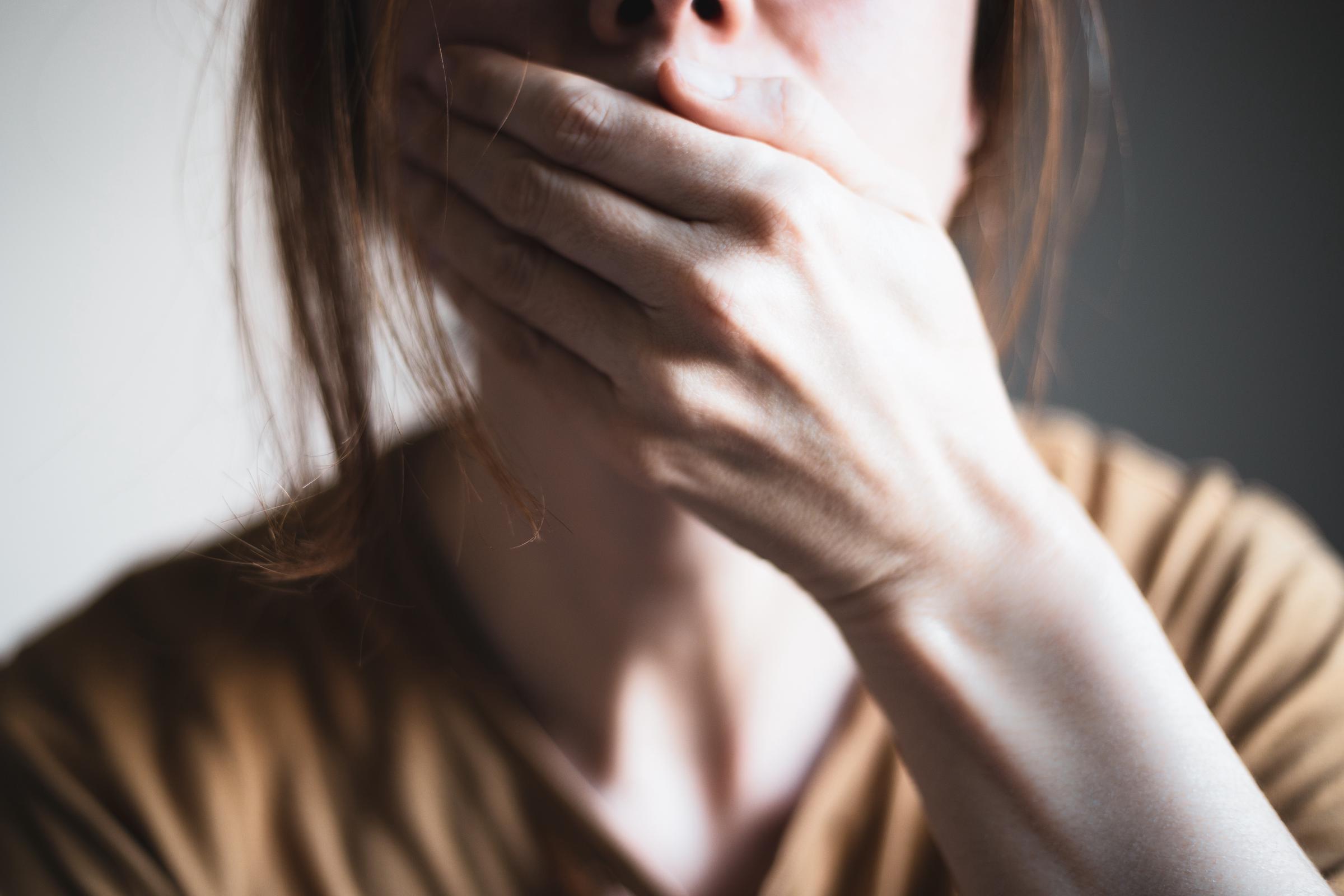 Eine Frau, die ihren Mund mit der Hand bedeckt  | Quelle: Getty Images