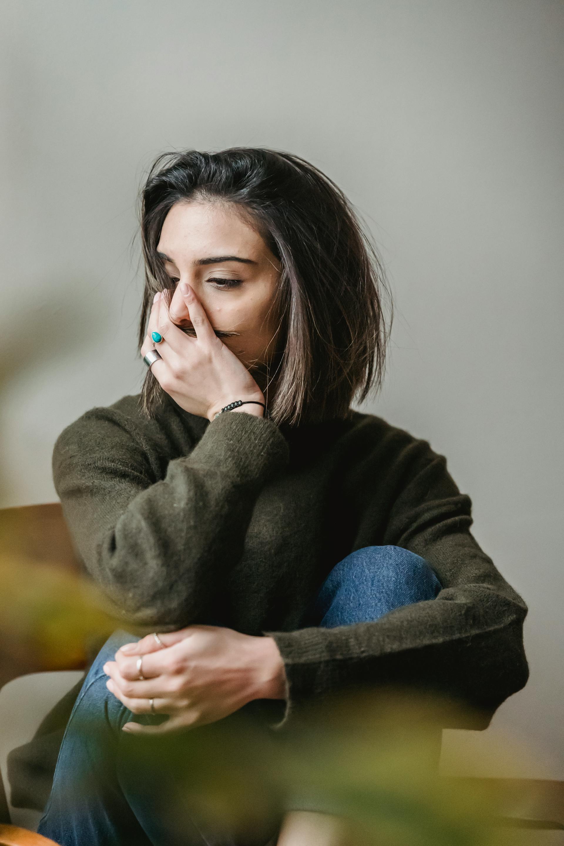 Eine traurige Frau, die auf der Couch sitzt | Quelle: Pexels