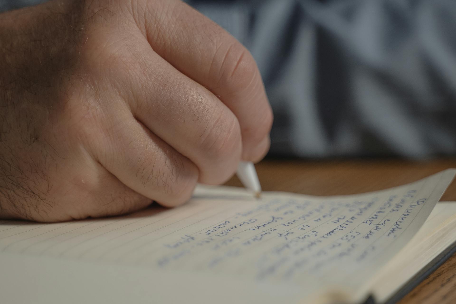 Eine Person, die auf Papier schreibt | Quelle: Pexels