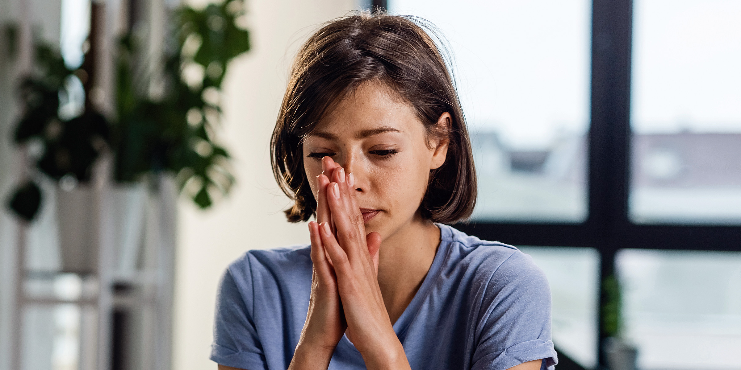 Eine sitzende Frau mit aneinandergehaltenen Handflächen | Quelle: Freepik