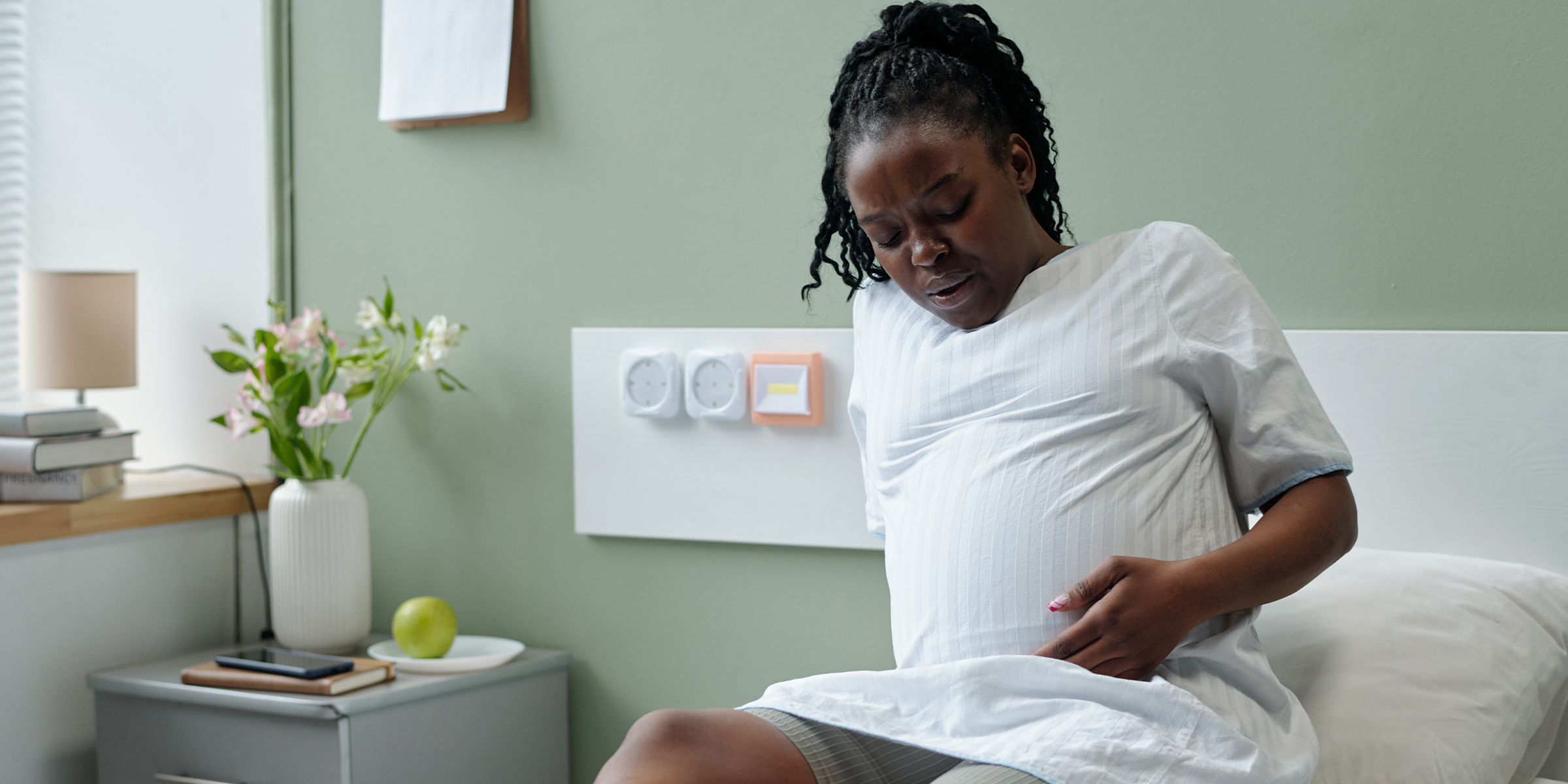 Eine schwangere Frau, die ihren Bauch hält | Quelle: Shutterstock