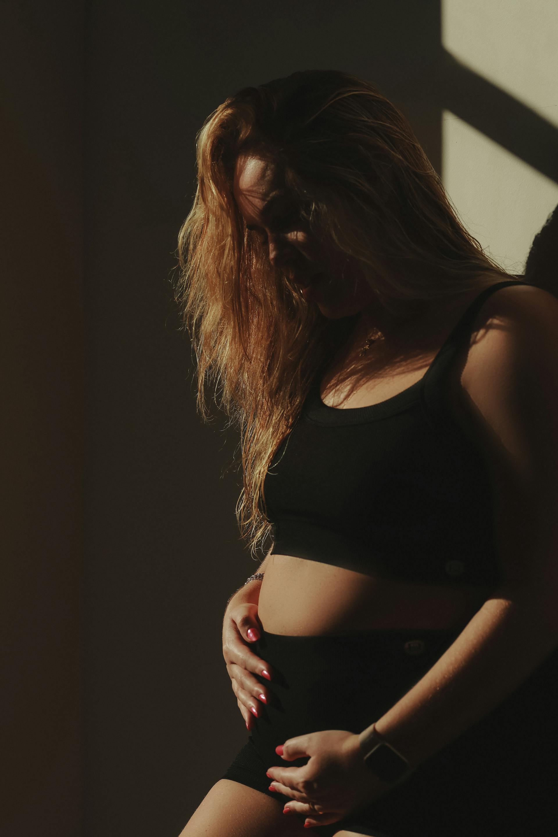 Eine schwangere Frau, die ihren Bauch berührt | Quelle: Pexels