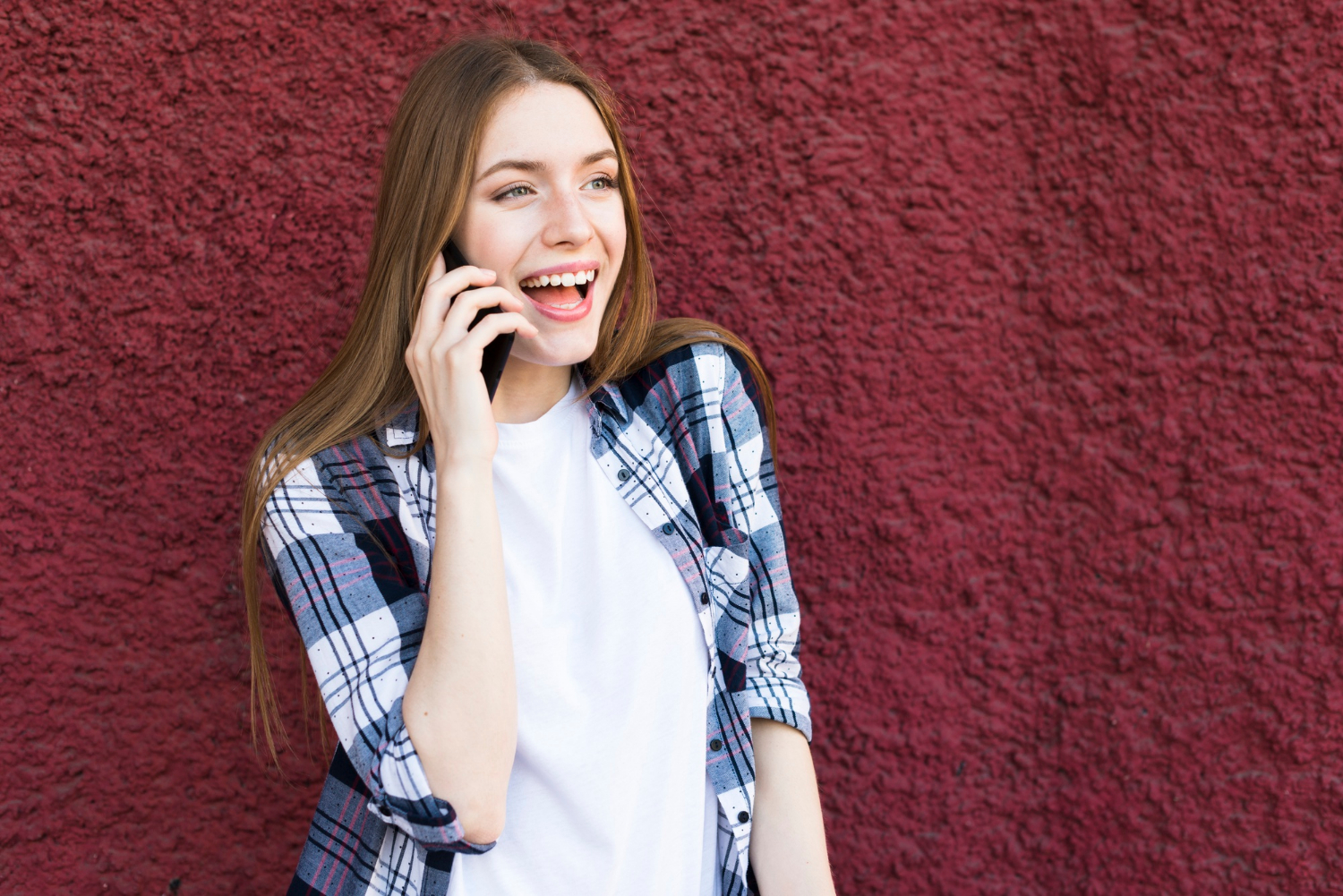 Eine fröhliche Frau, die telefoniert | Quelle: Freepik