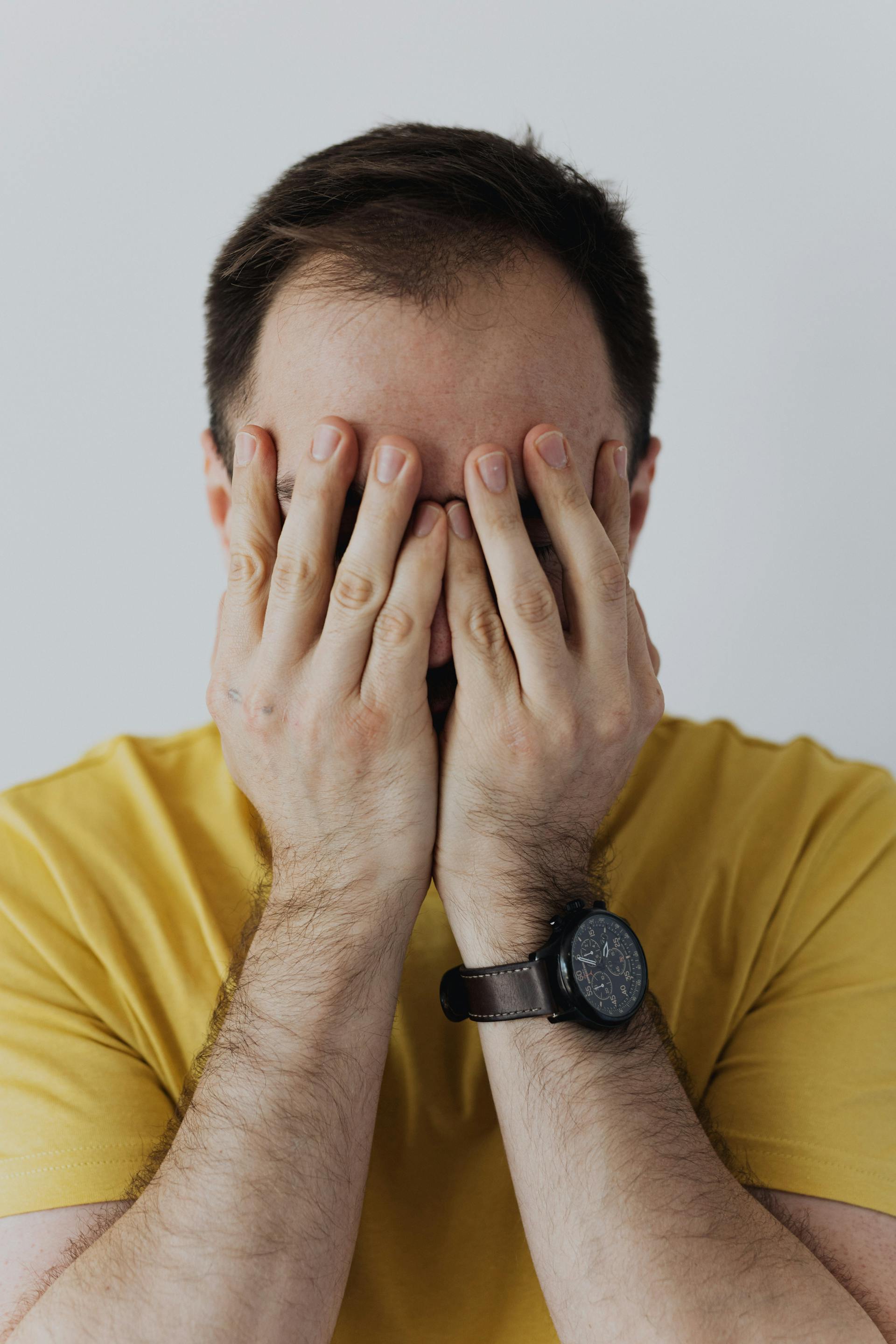 Ein Mann, der sein Gesicht mit seinen Händen bedeckt | Quelle: Pexels