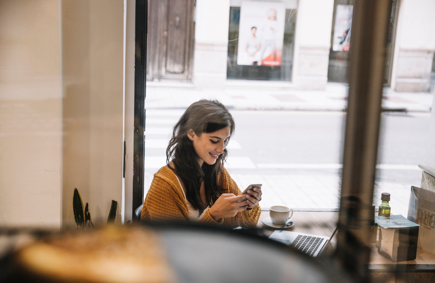 Eine Frau schaut auf ihr Telefon und lächelt | Quelle: Freepik