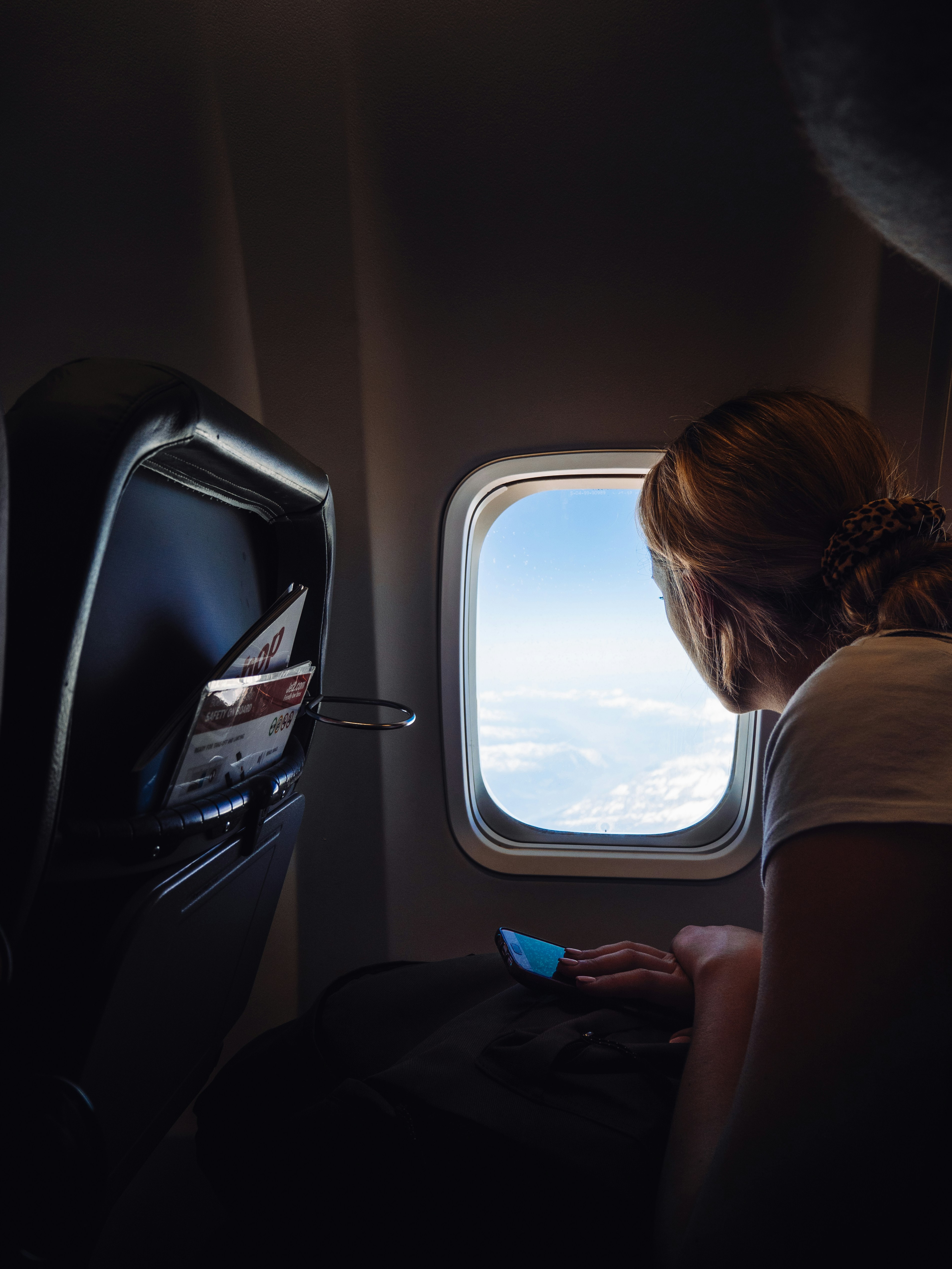 Eine Frau, die in einem Flugzeug sitzt und nach draußen schaut | Quelle: Unsplash