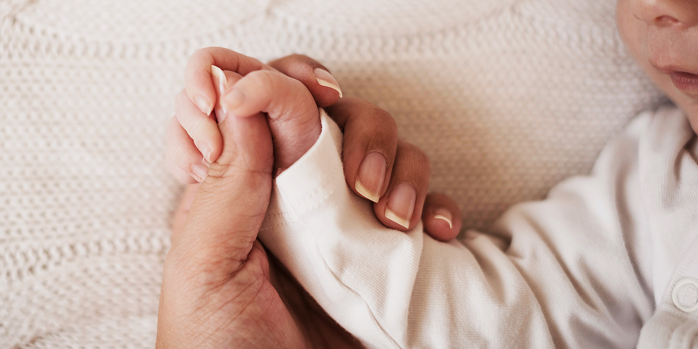Eine Frau hält die Hand eines Babys | Quelle: Freepik