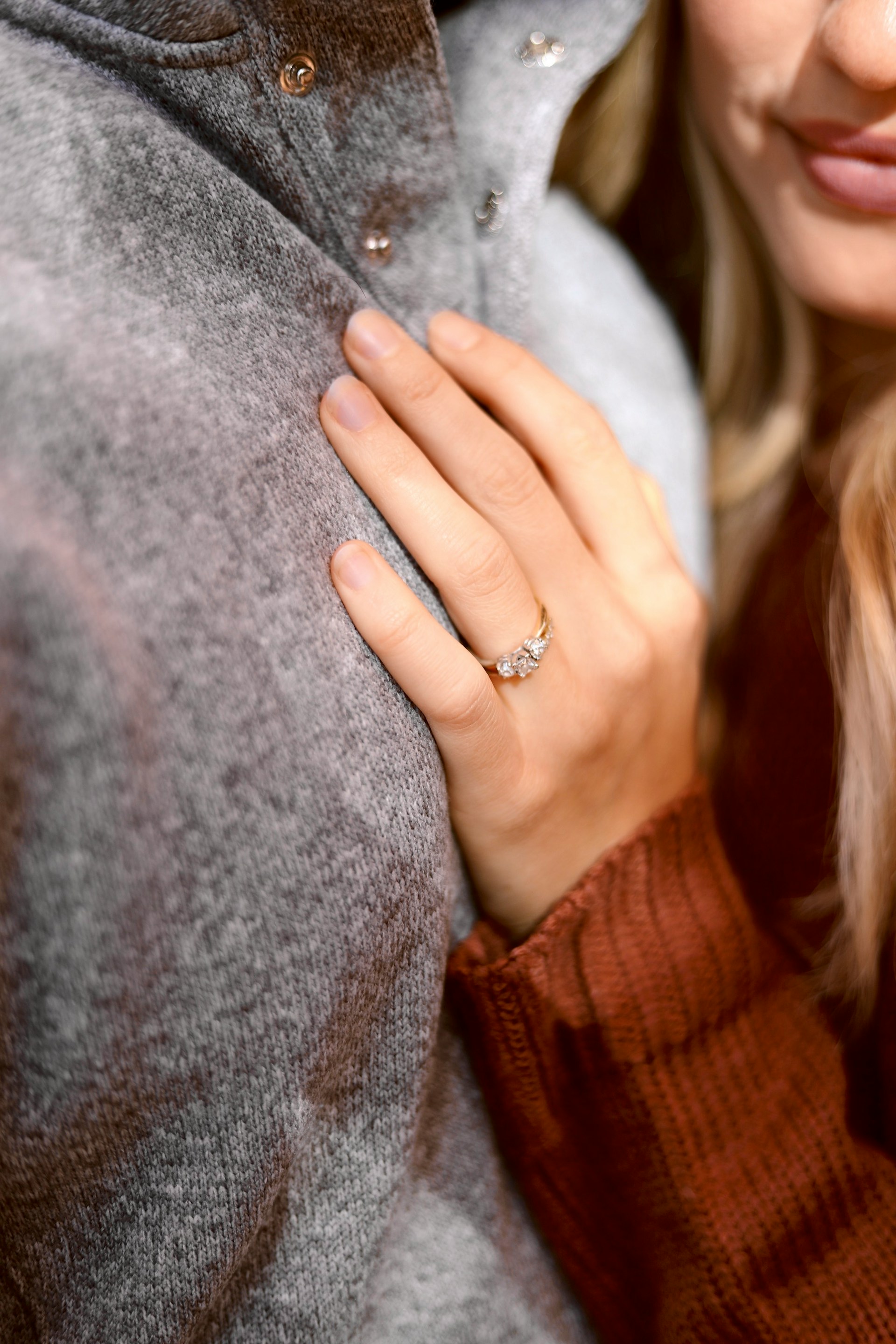 Eine begeisterte Frau, die ihren Partner umarmt und ihren Verlobungsring zur Schau stellt | Quelle: Unsplash