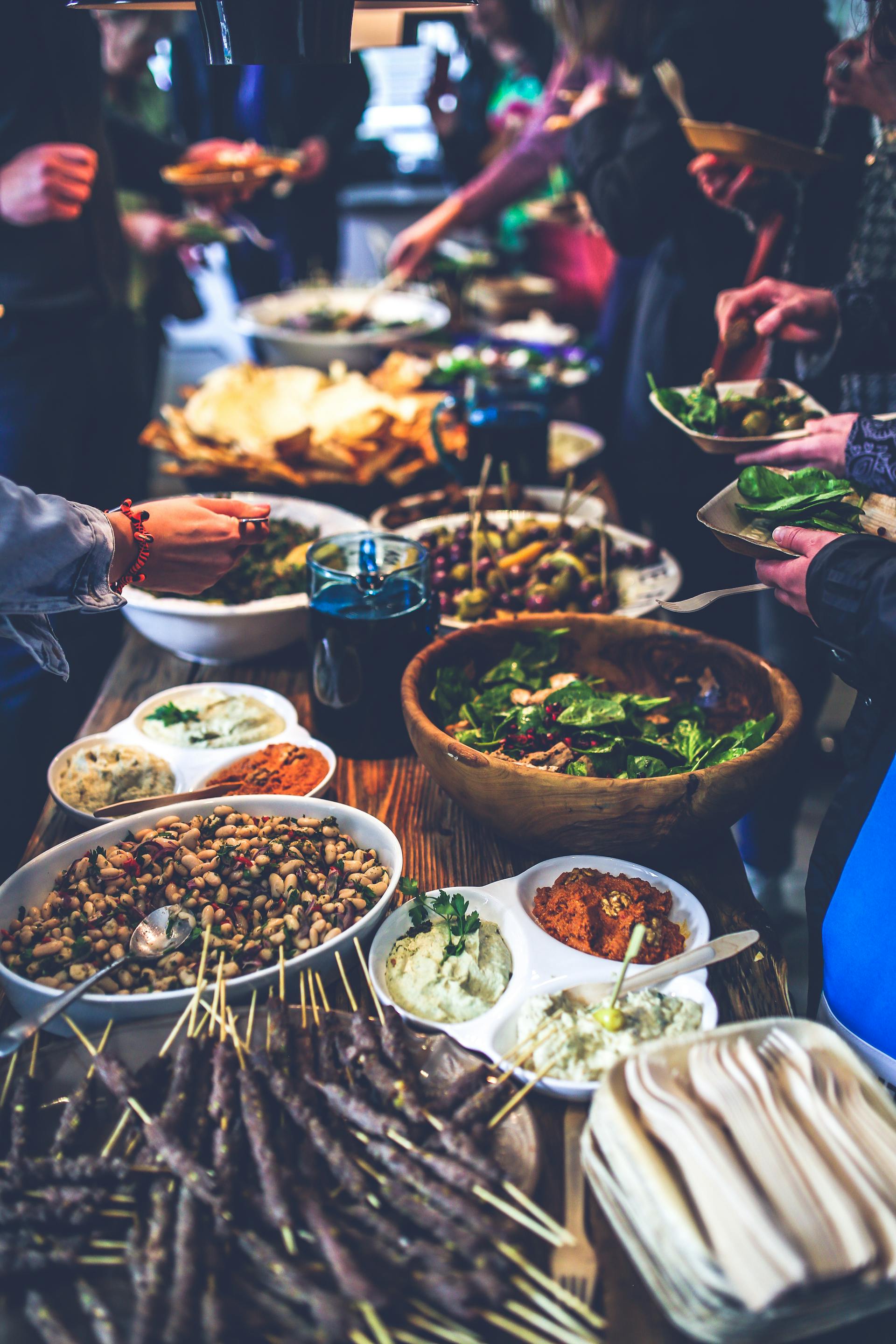 Menschen, die Essen von einem Buffet auftischen | Quelle: Pexels