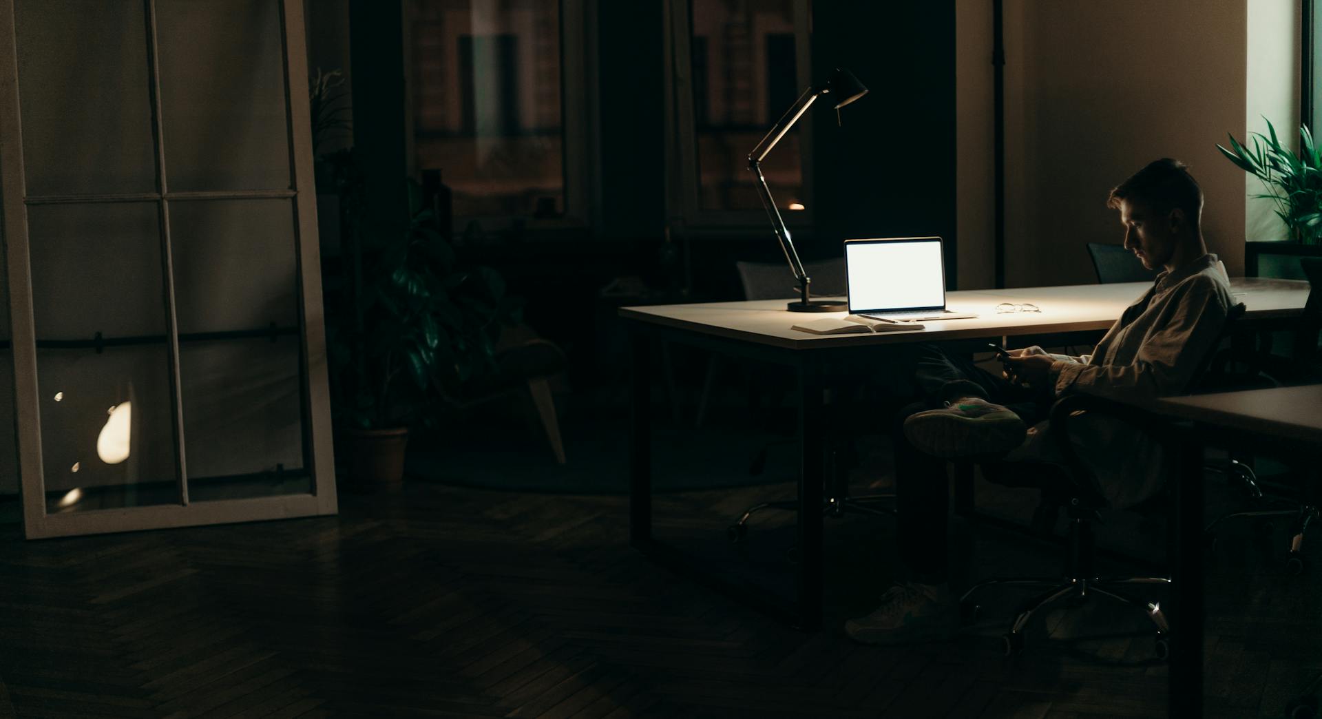 Ein Mann sitzt nachts in seinem Büro | Quelle: Pexels