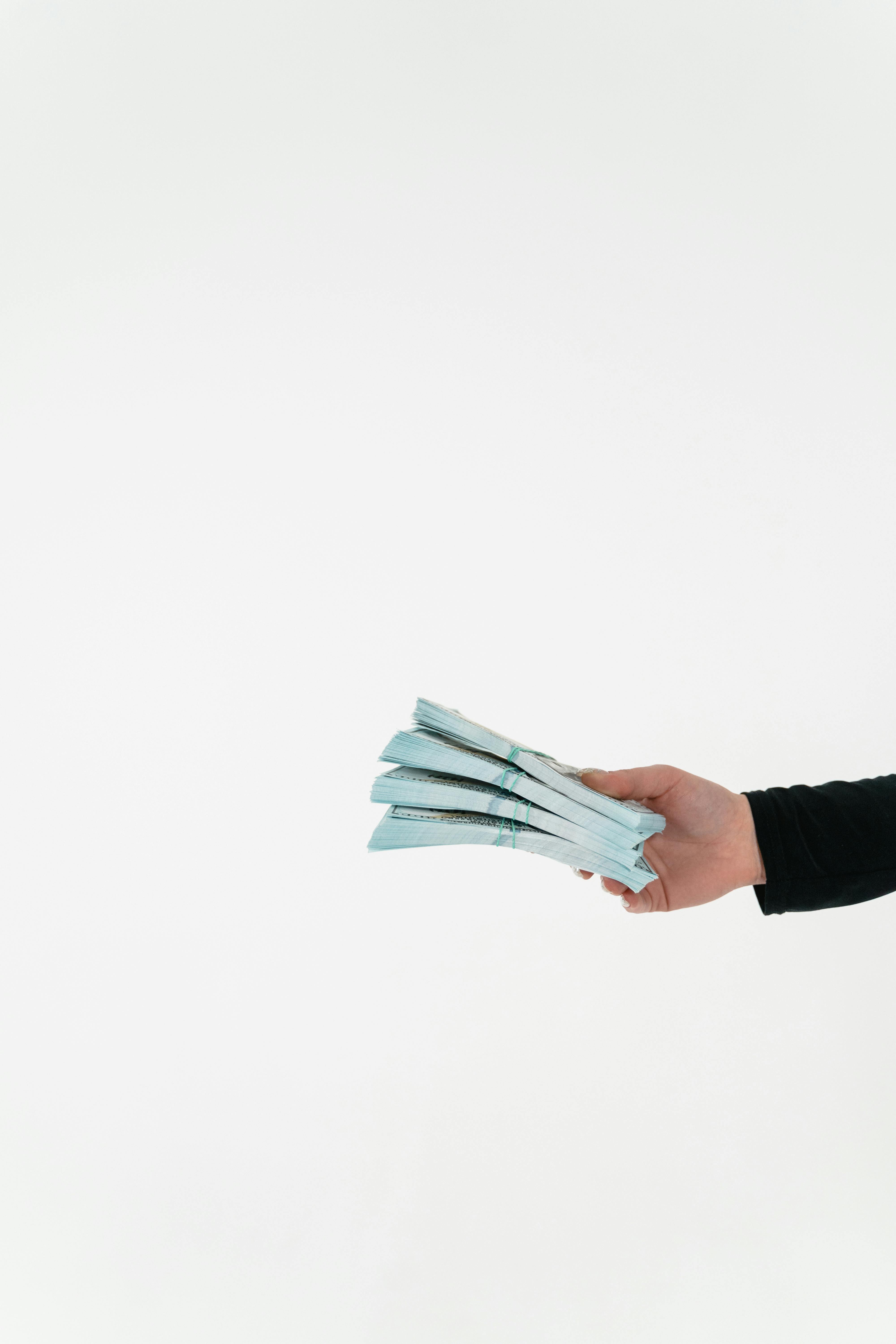 Eine Person hält ein Bündel Bargeld in der Hand | Quelle: Pexels