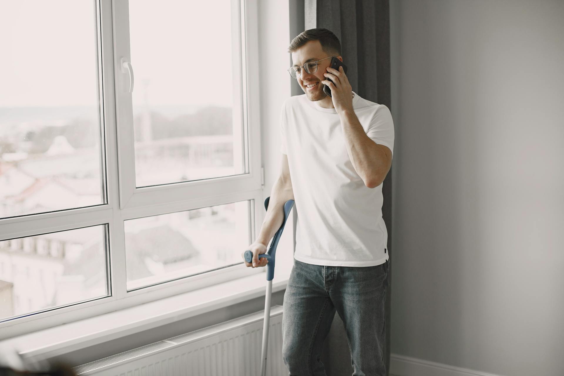 Ein Mann benutzt eine Unterarmgehstütze während eines Telefonats | Quelle: Pexels