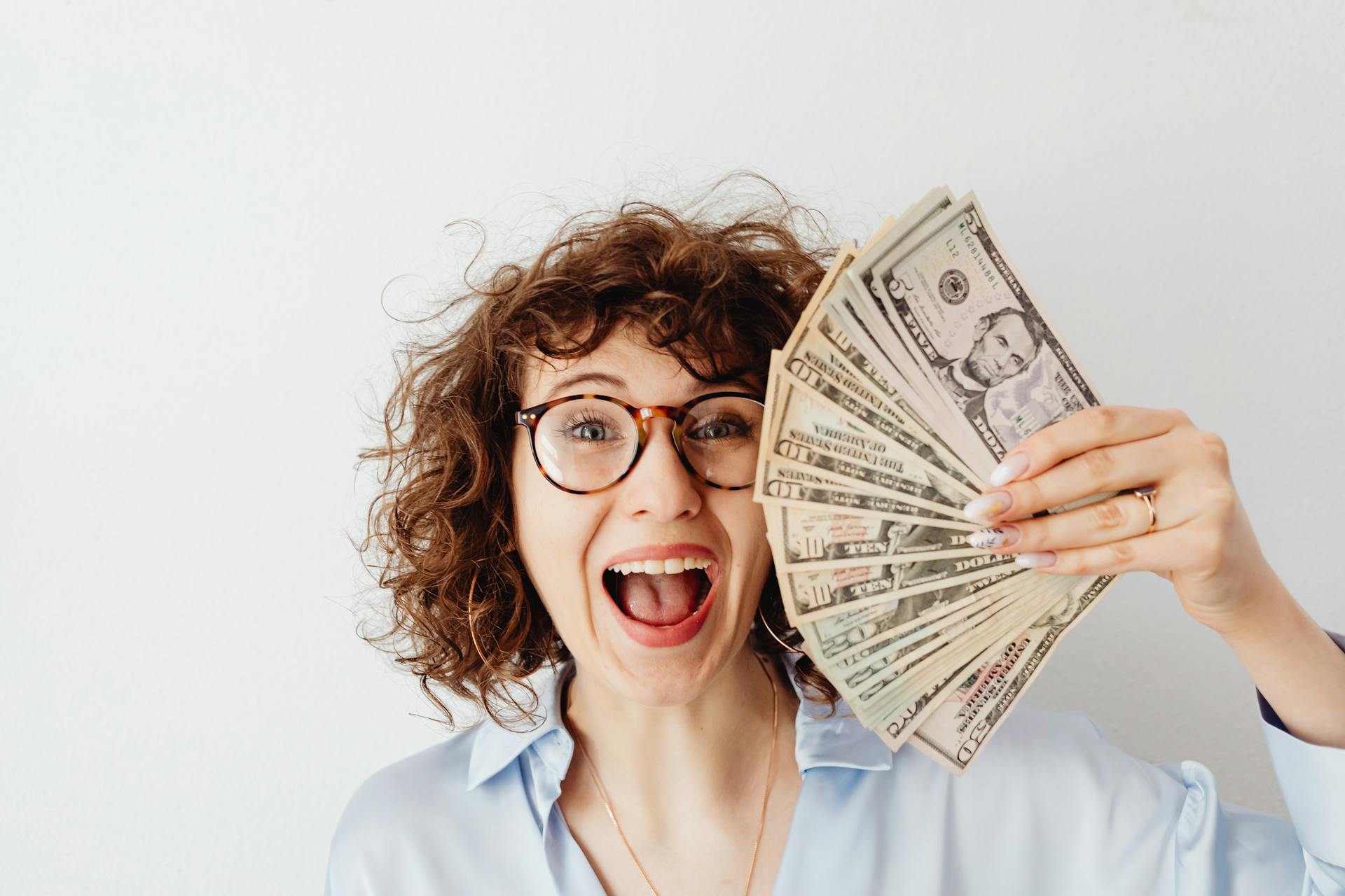 Eine Frau hält Geld hoch | Quelle: Pexels