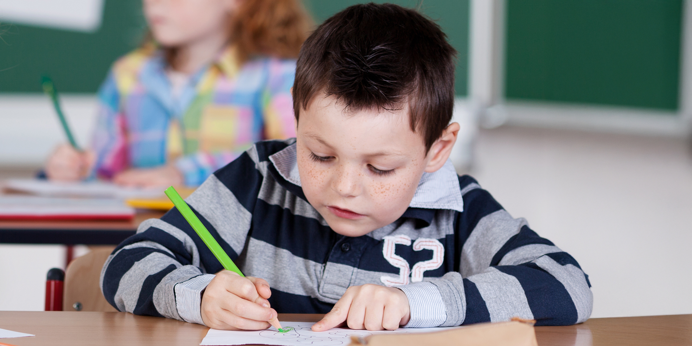 Ein Junge malt ein Bild in der Klasse | Quelle: Shutterstock