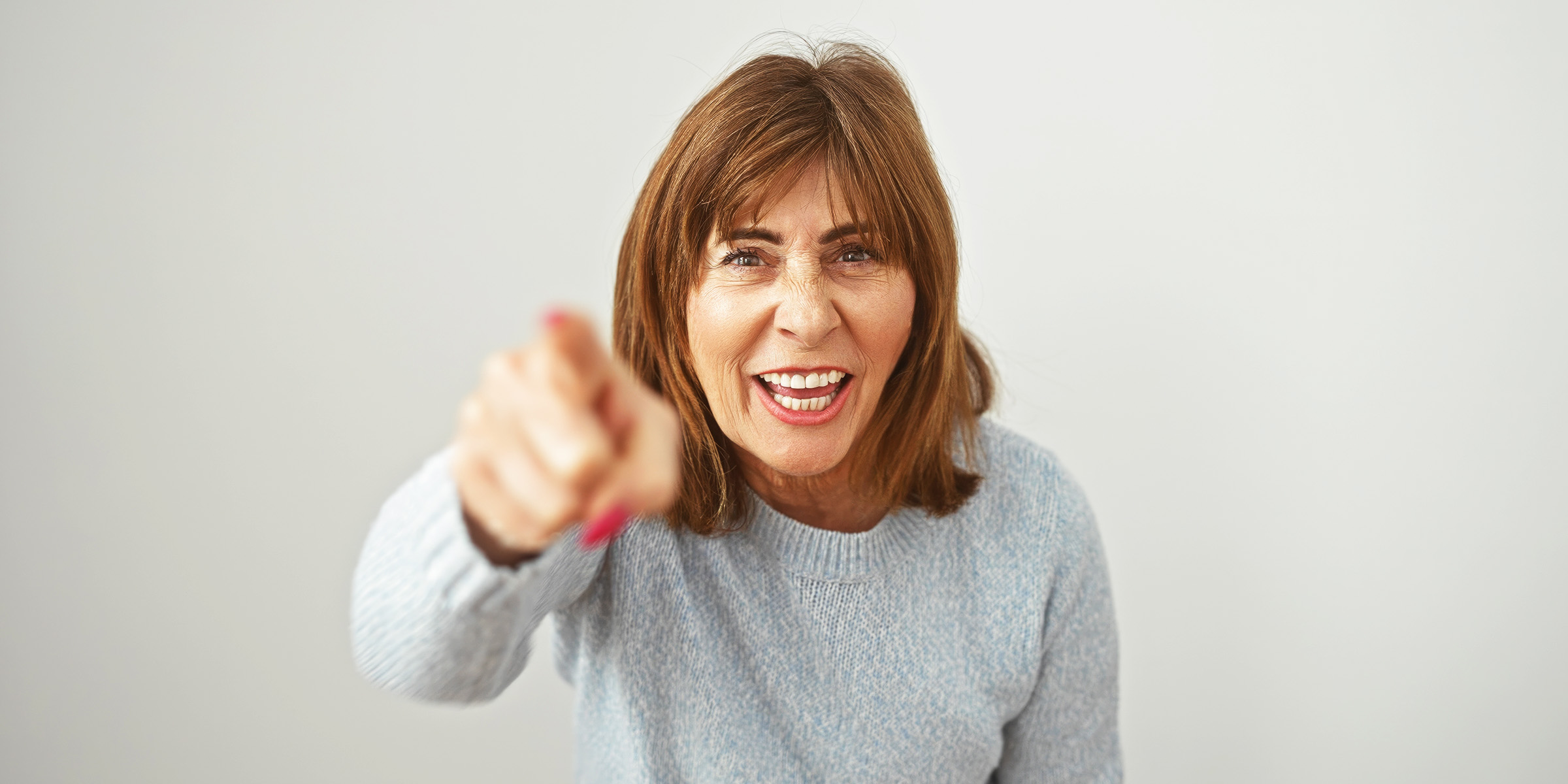 Eine Frau, die wütend nach vorne zeigt | Quelle: Shutterstock