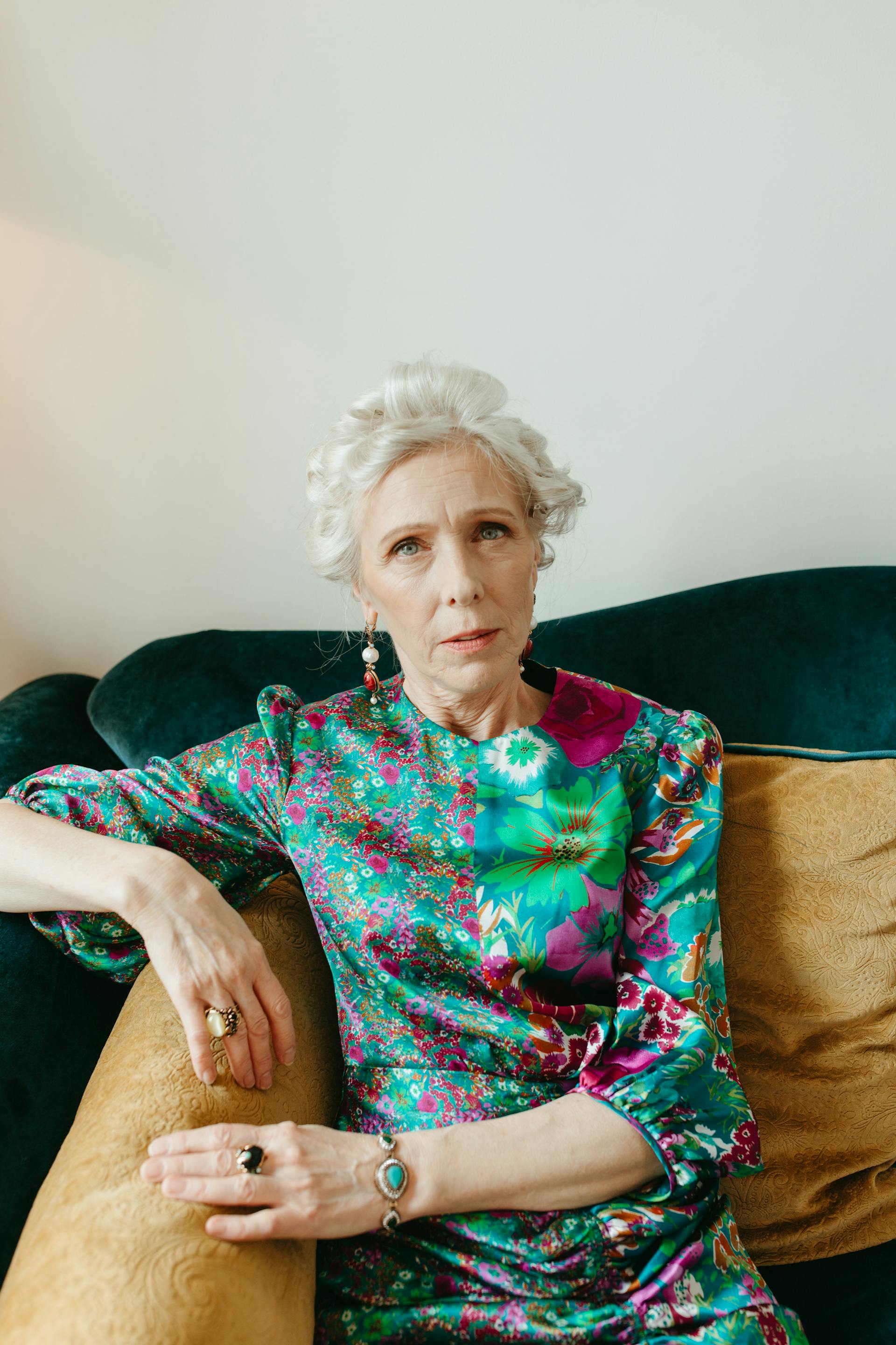 Eine ältere Frau, die auf der Couch sitzt und jemanden anschaut | Quelle: Pexels