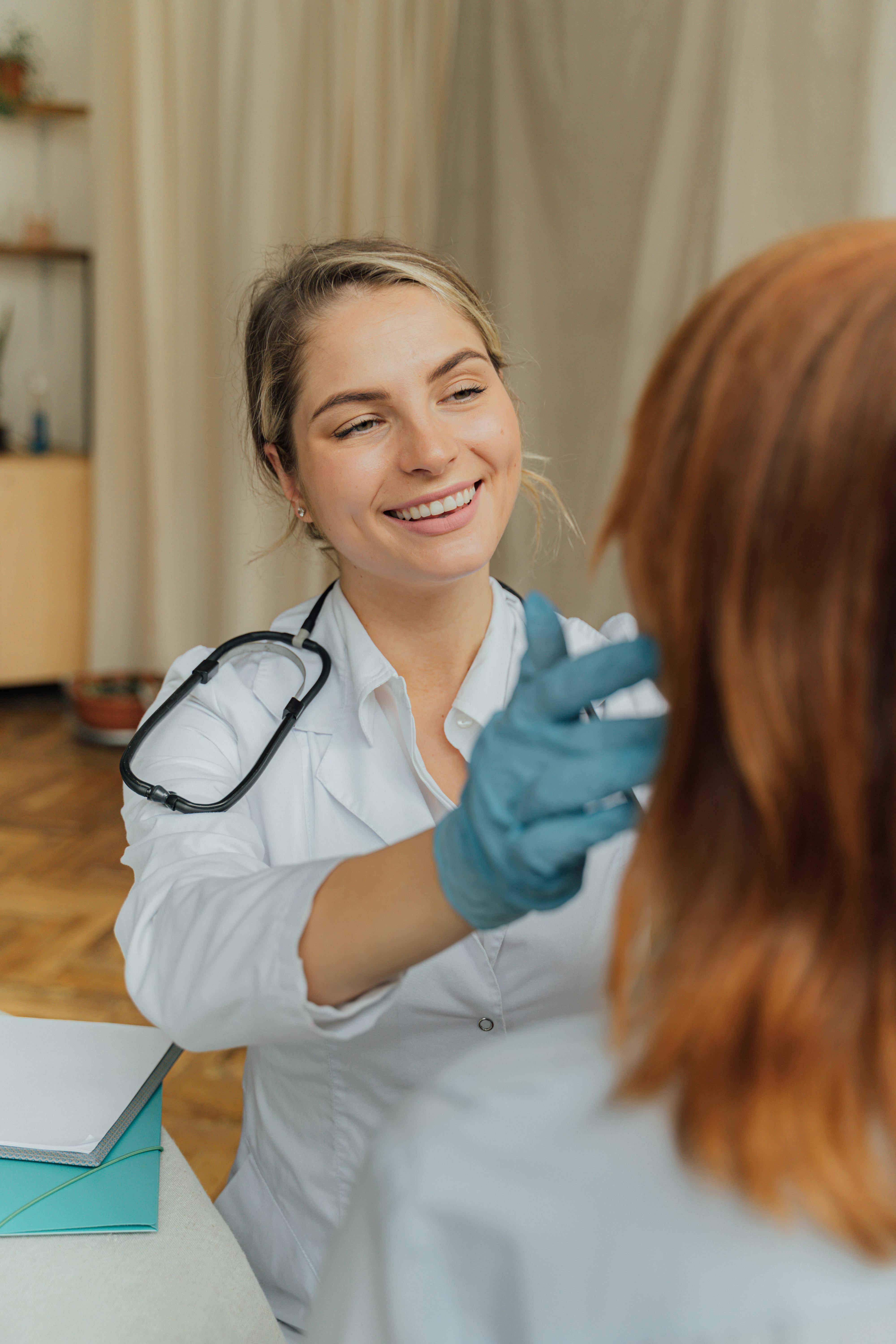 Eine glückliche Krankenschwester, die einem Patienten hilft | Quelle: Pexels