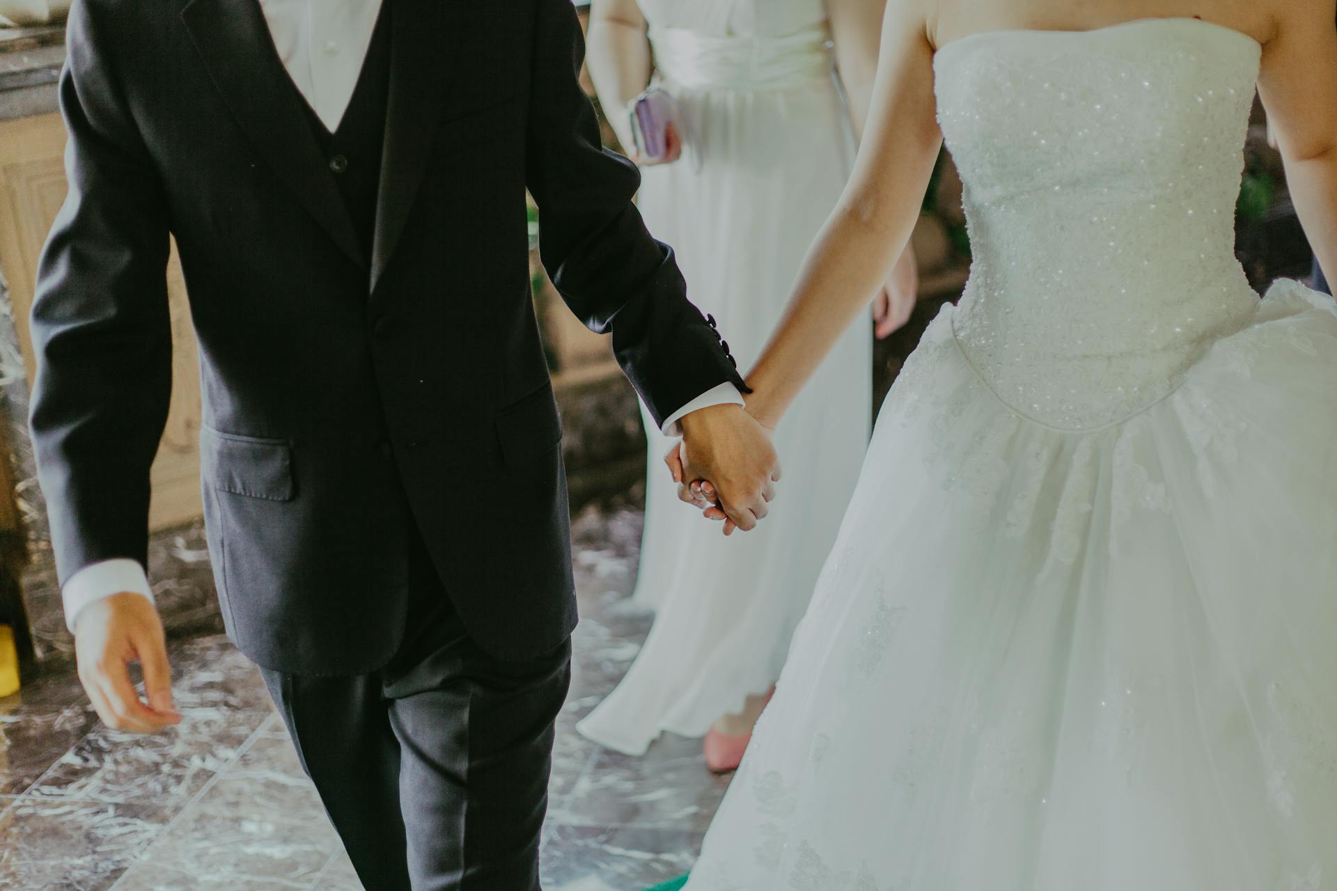 Eine Braut und ein Bräutigam gehen Hand in Hand | Quelle: Pexels