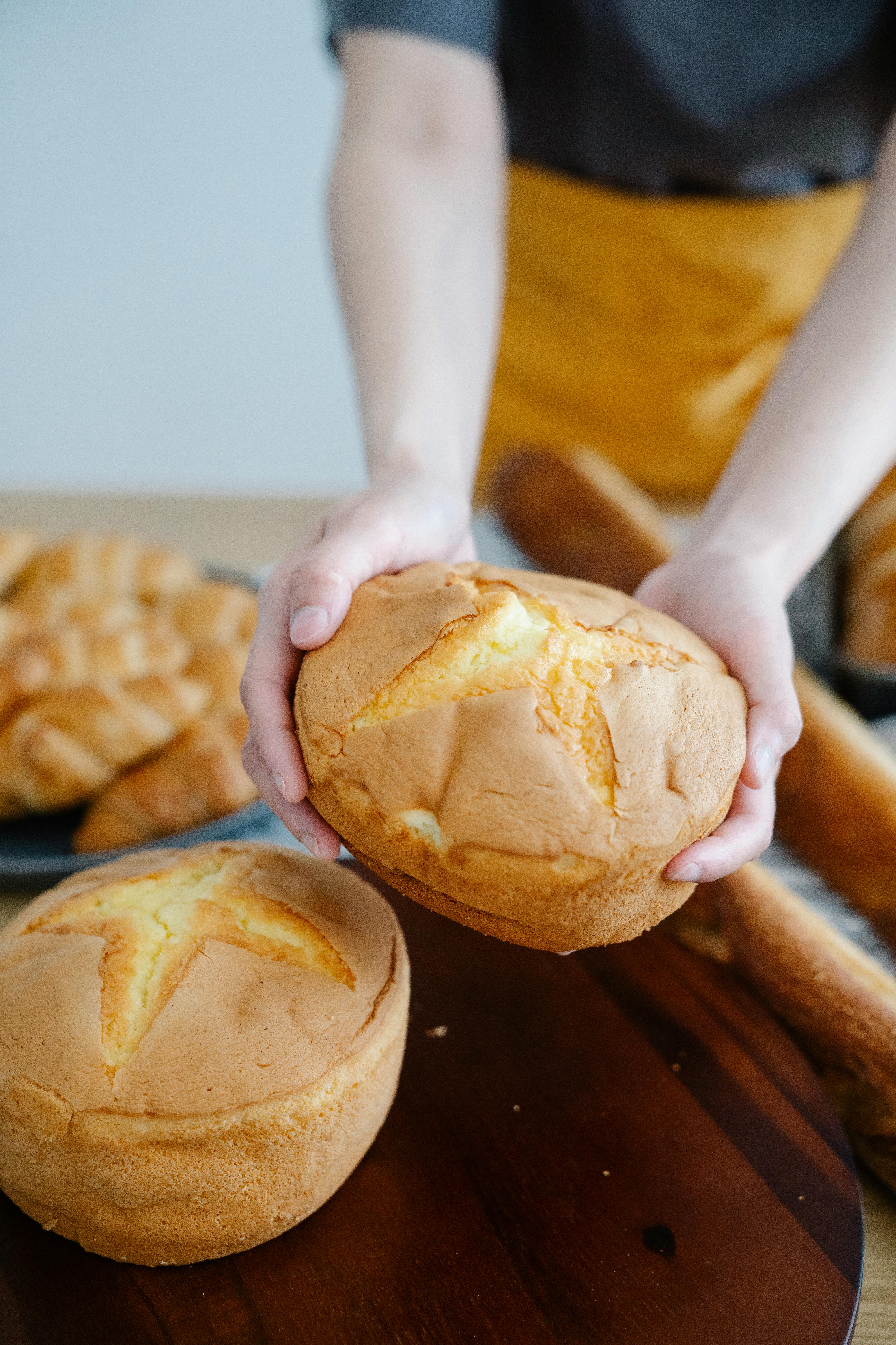 Frau hält ein frisch gebackenes Brot | Quelle: Pexels
