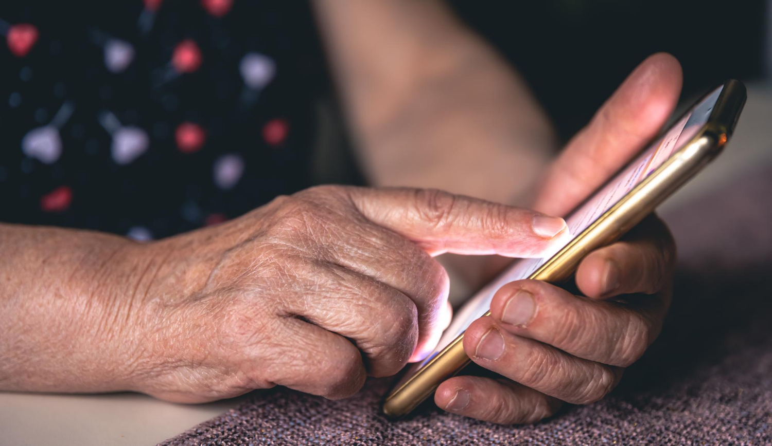 Nahaufnahme einer älteren Frau, die ein Telefon hält | Quelle: Freepik