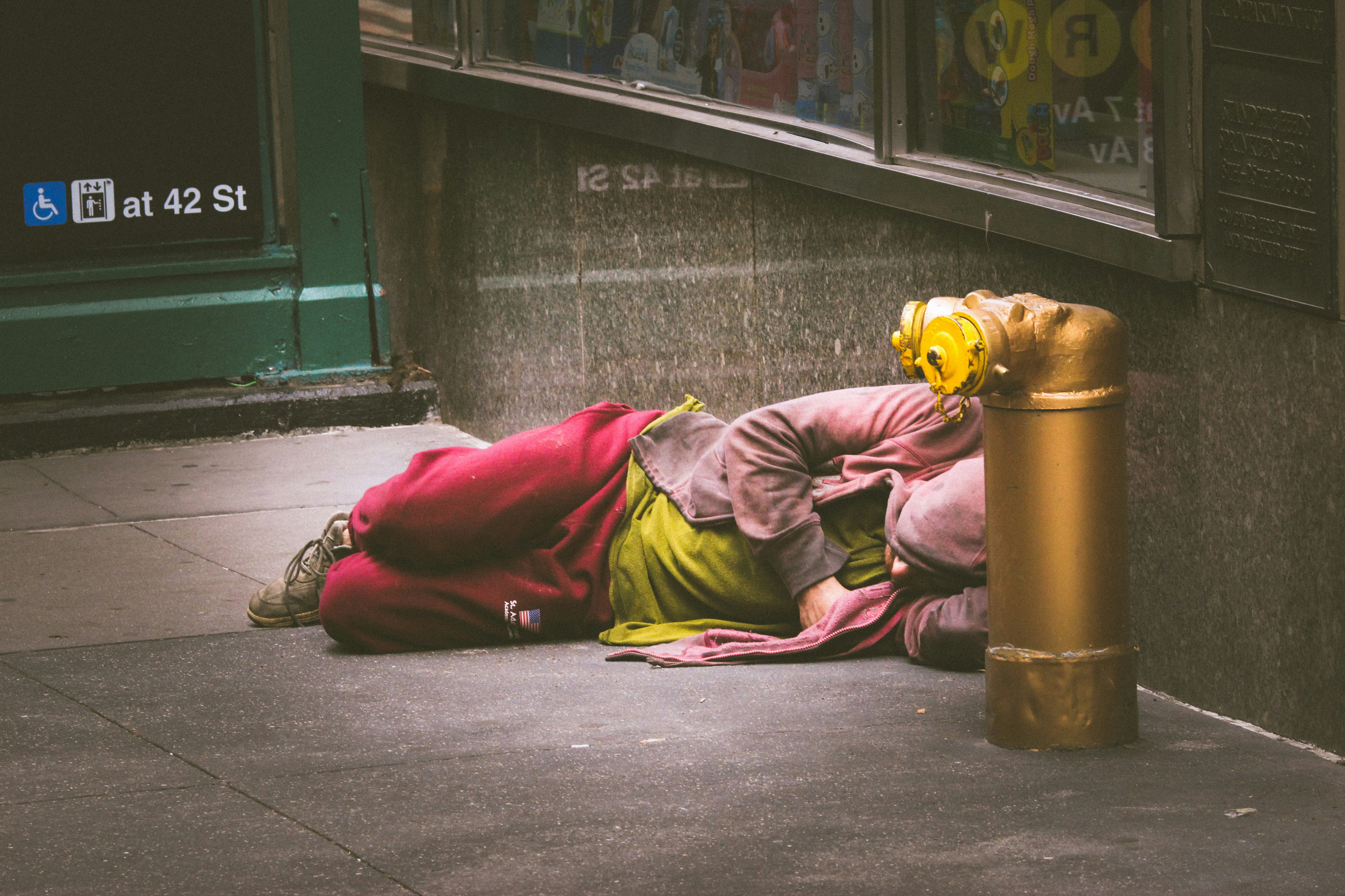Eine obdachlose Person, die auf dem Boden schläft | Quelle: Unsplash