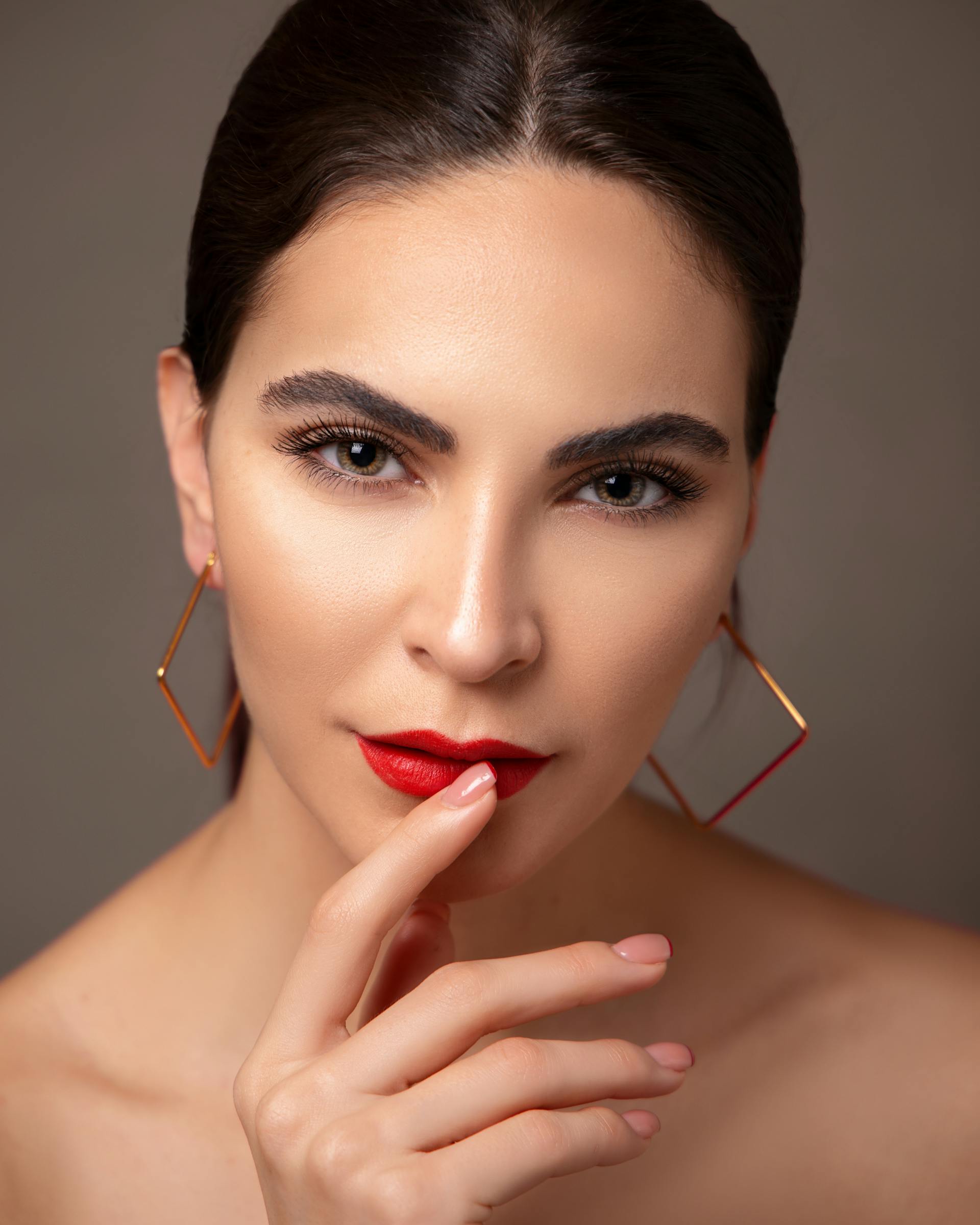 Eine Frau mit rotem Lippenstift und Ohrringen | Quelle: Pexels