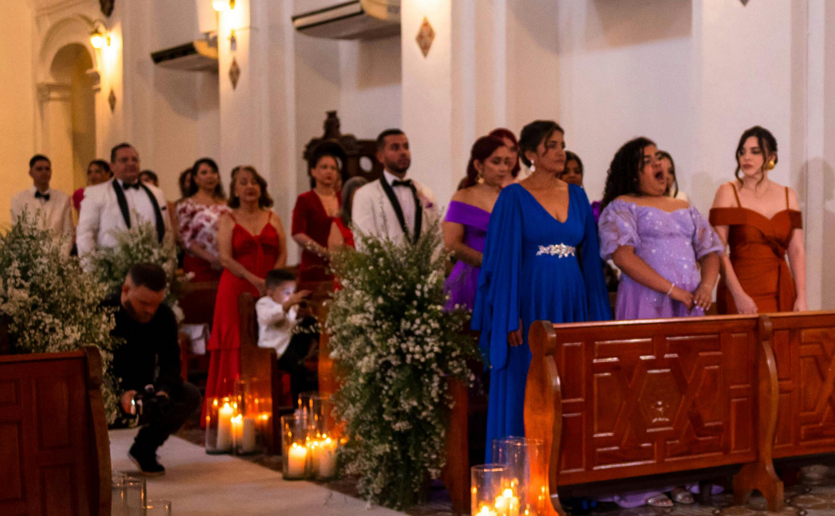 Hochzeitsgäste, die an den Kirchenbänken stehen | Quelle: Pexels