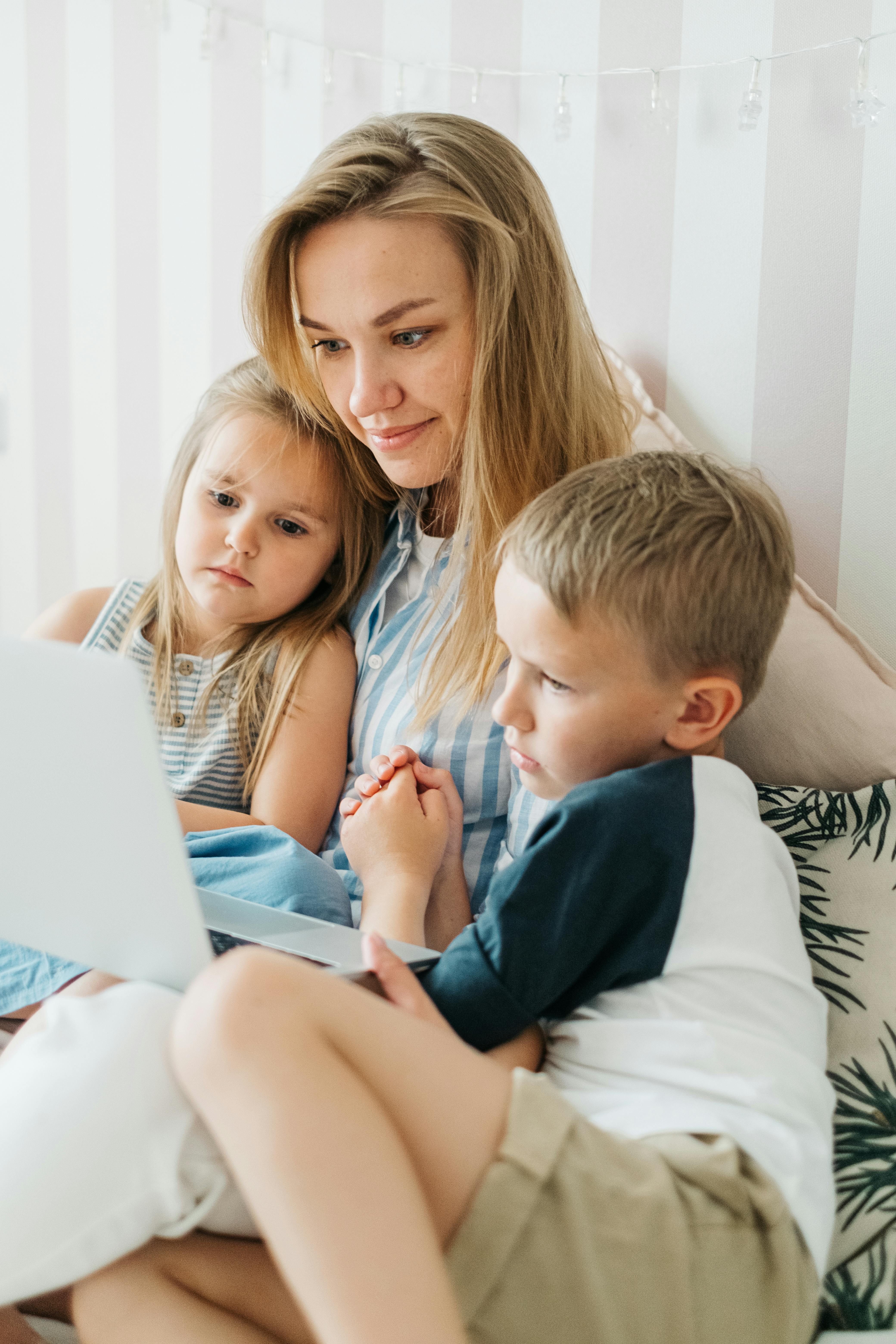 Eine Frau und ihre Kinder benutzen einen Laptop | Quelle: Pexels