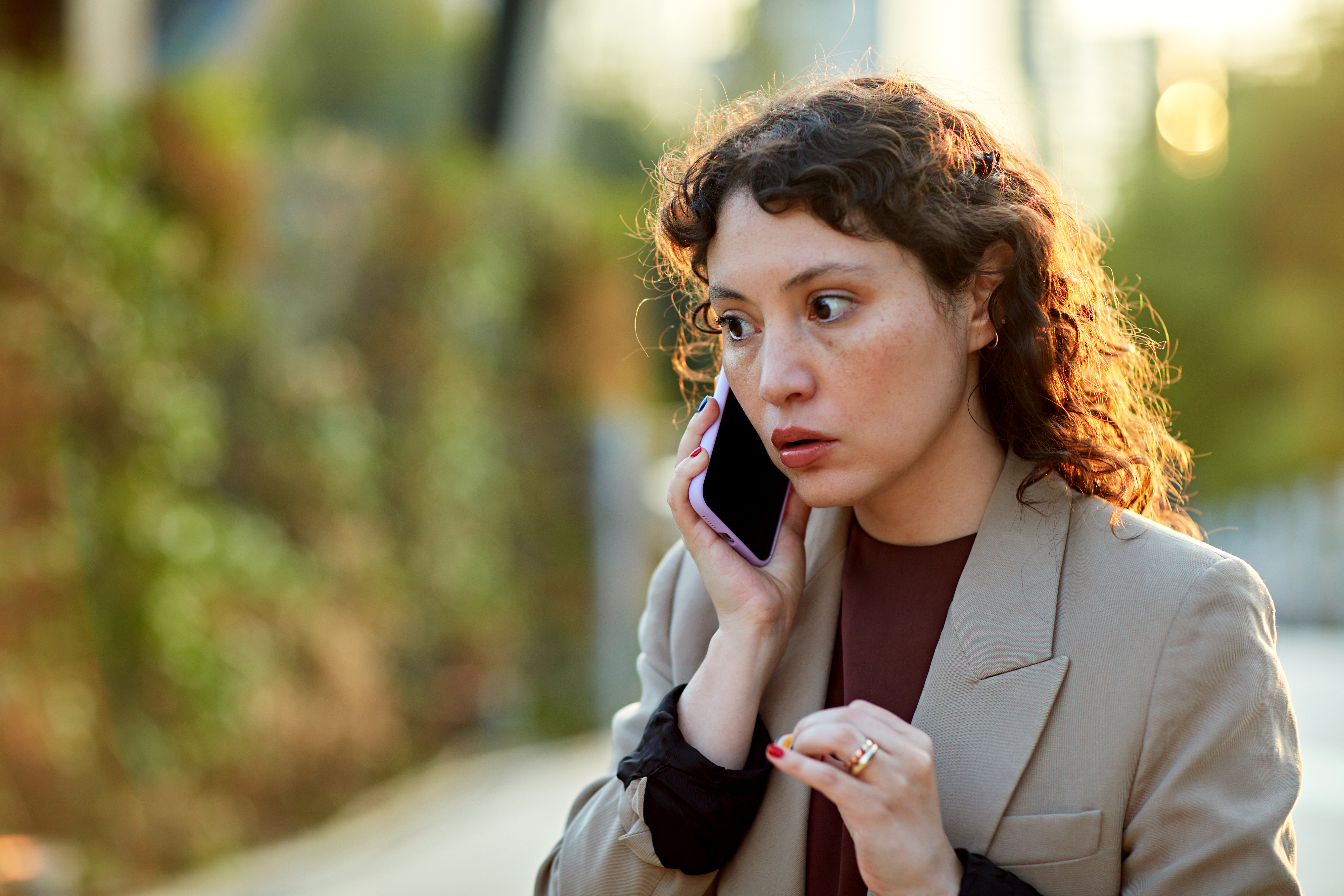 Besorgte Geschäftsfrau beim Telefonieren im Freien | Quelle: Getty Images