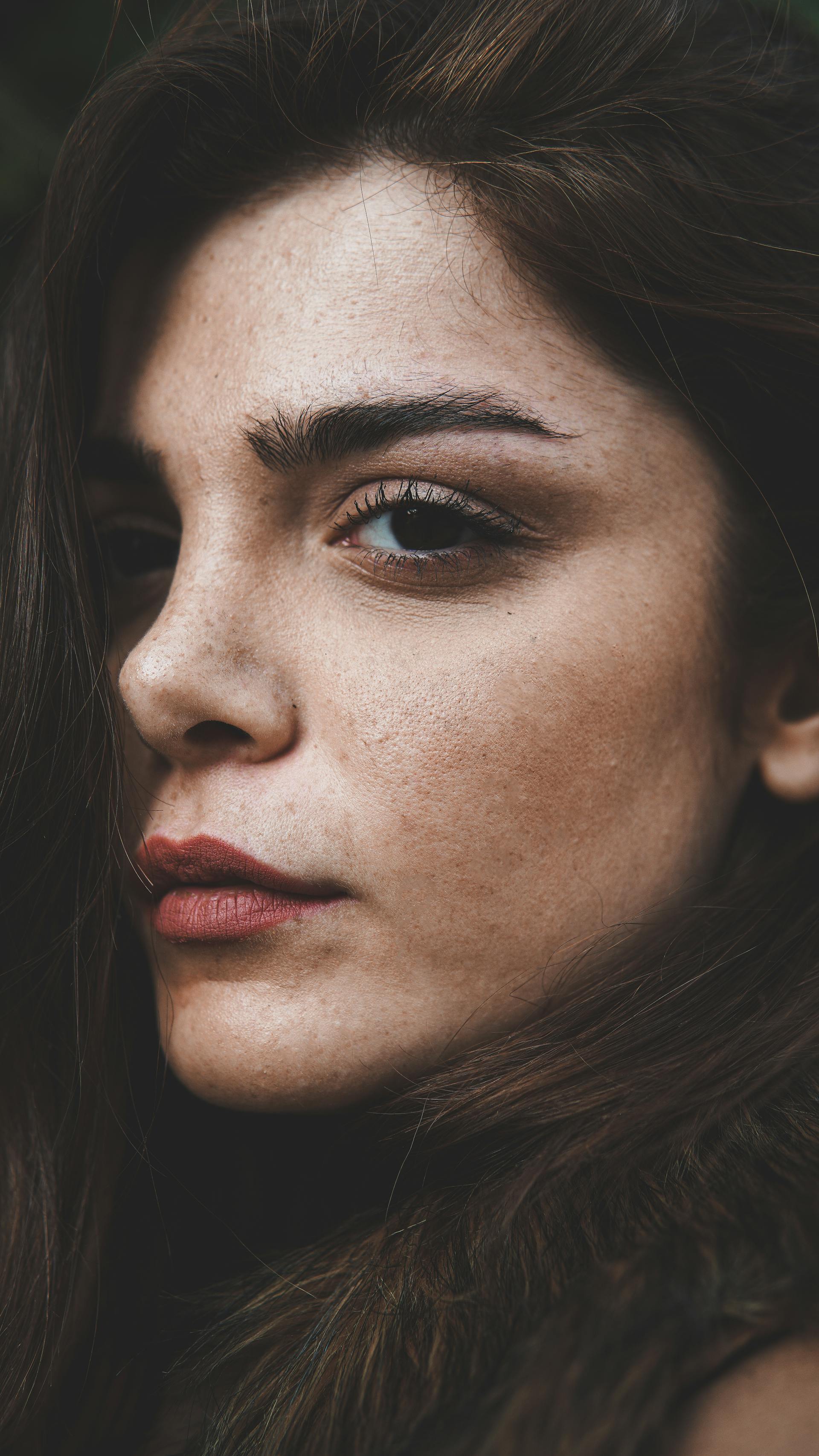 Eine Frau mit Sommersprossen, die zur Seite schaut | Quelle: Pexels