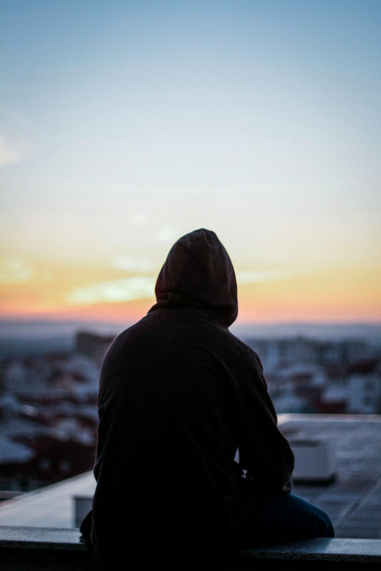 Silhouette einer traurigen Person, die auf einer Bank sitzt | Quelle: Pexels