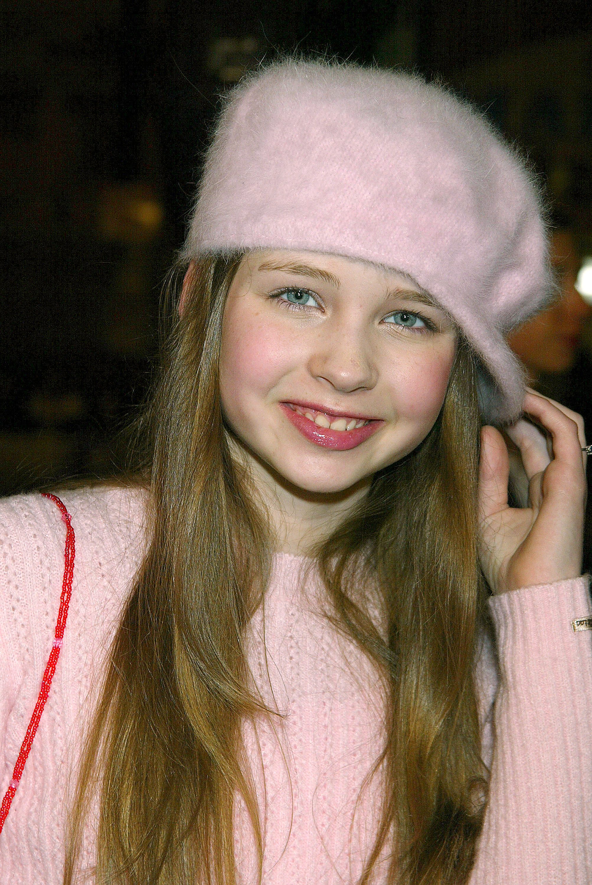 In einem rosa Pullover und einer dazu passenden Baskenmütze erscheint Daveigh Chase auf dem Höhepunkt ihrer frühen Hollywood-Karriere bei der Premiere von „Along Came Polly“ im Grauman’s Chinese Theatre. | Quelle: Getty Images