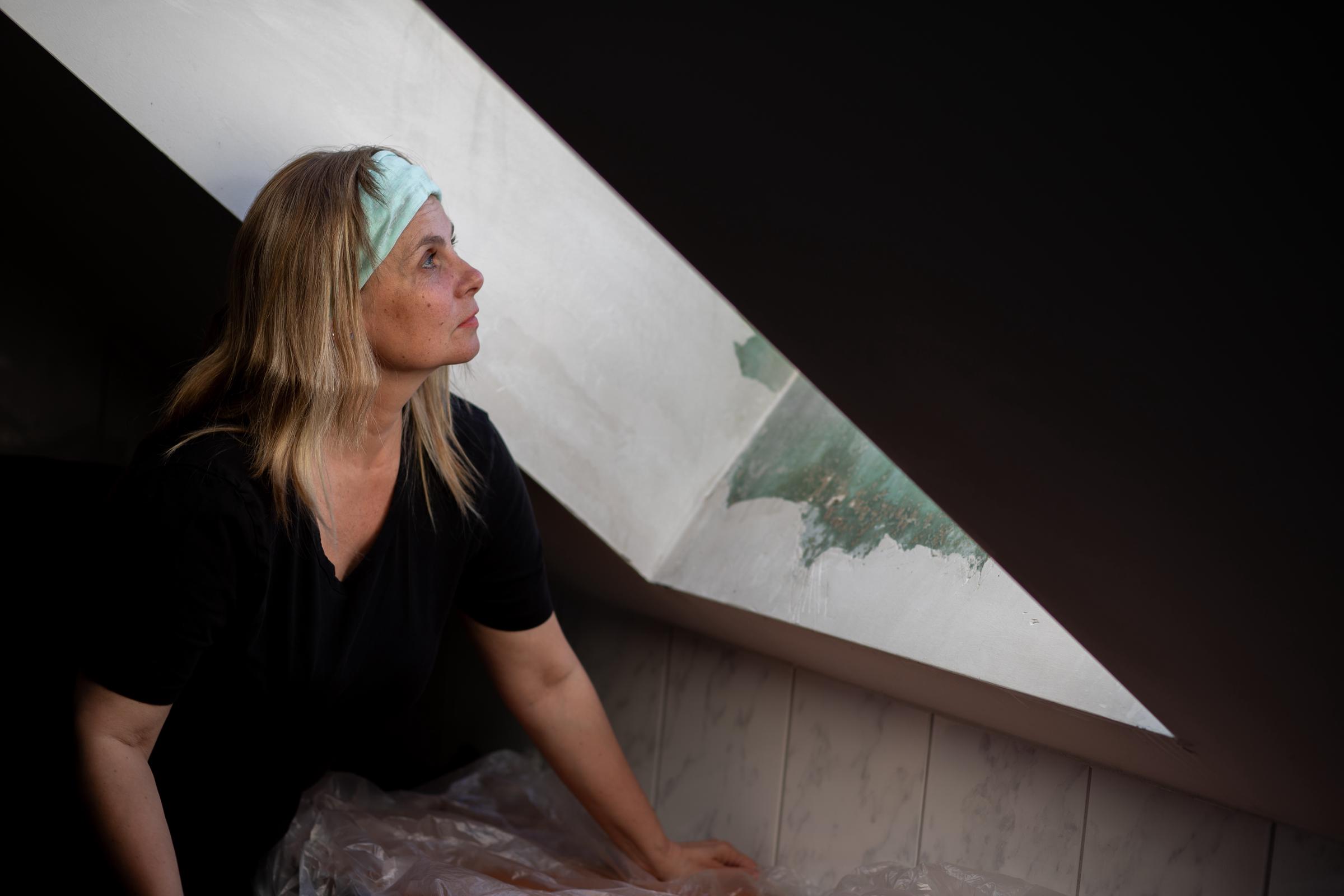 Frau schaut auf das Dachbodenfenster | Quelle: Shutterstock