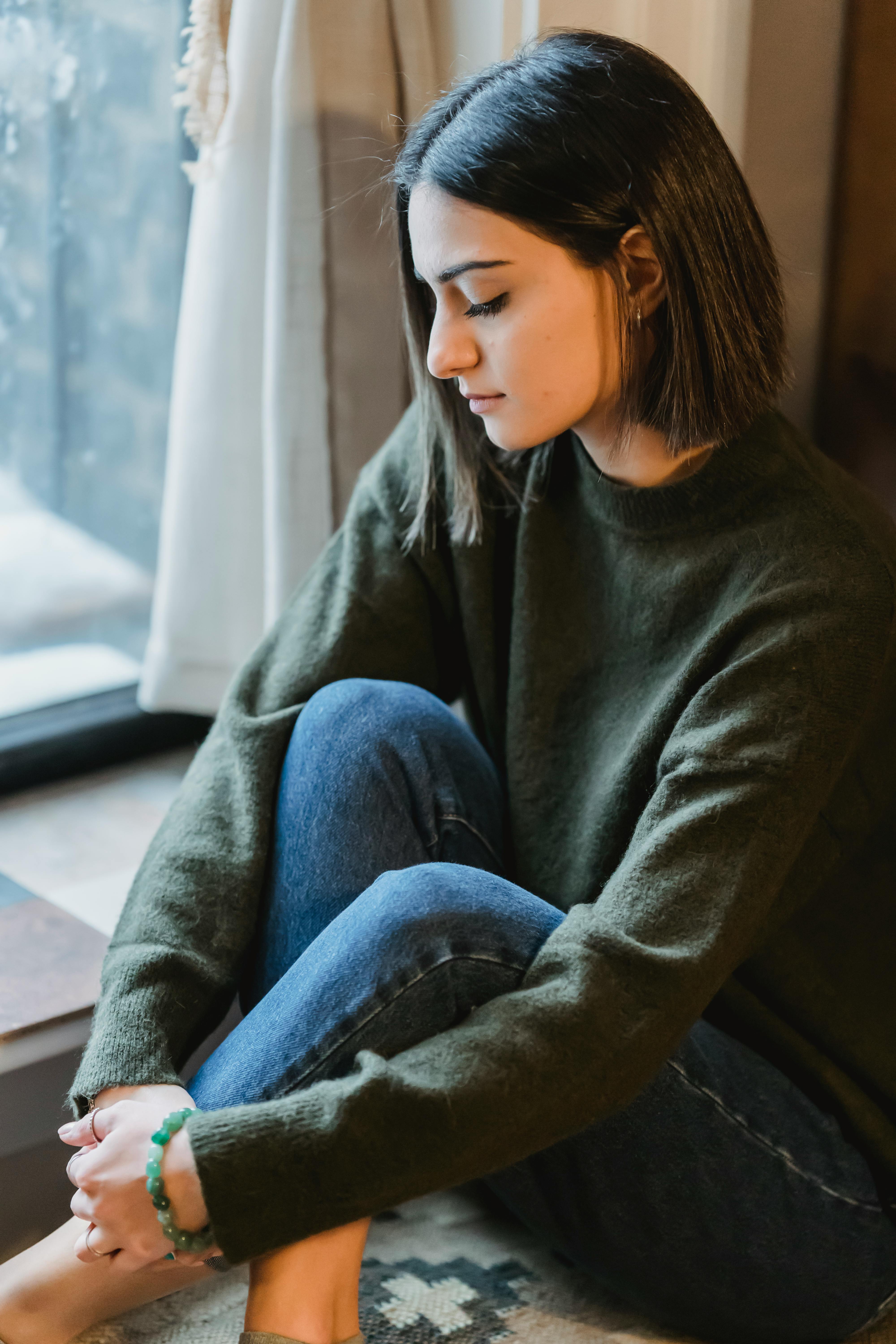 Eine traurige Frau im Sitzen | Quelle: Pexels