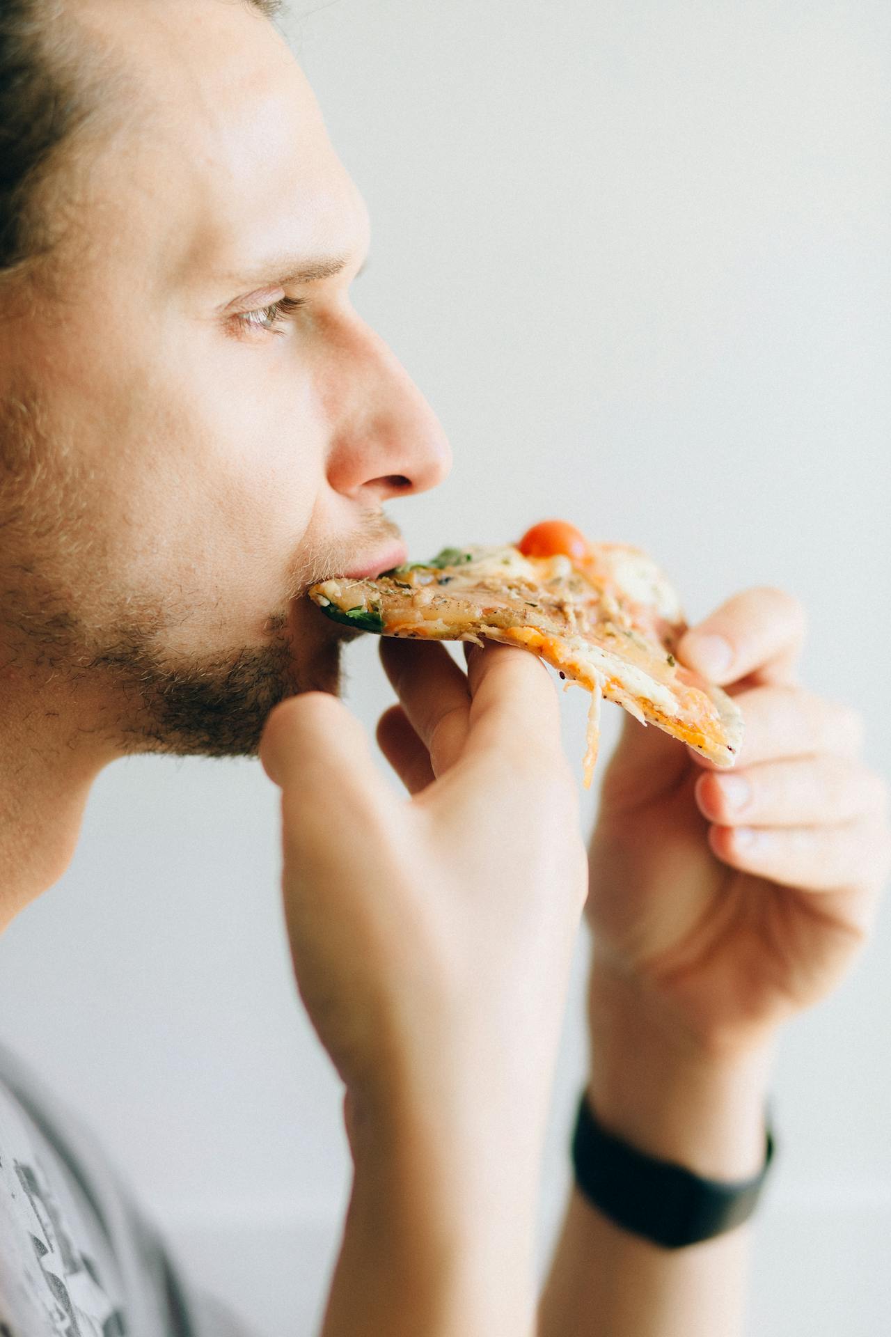 Ein Mann isst Pizza | Quelle: Pexels