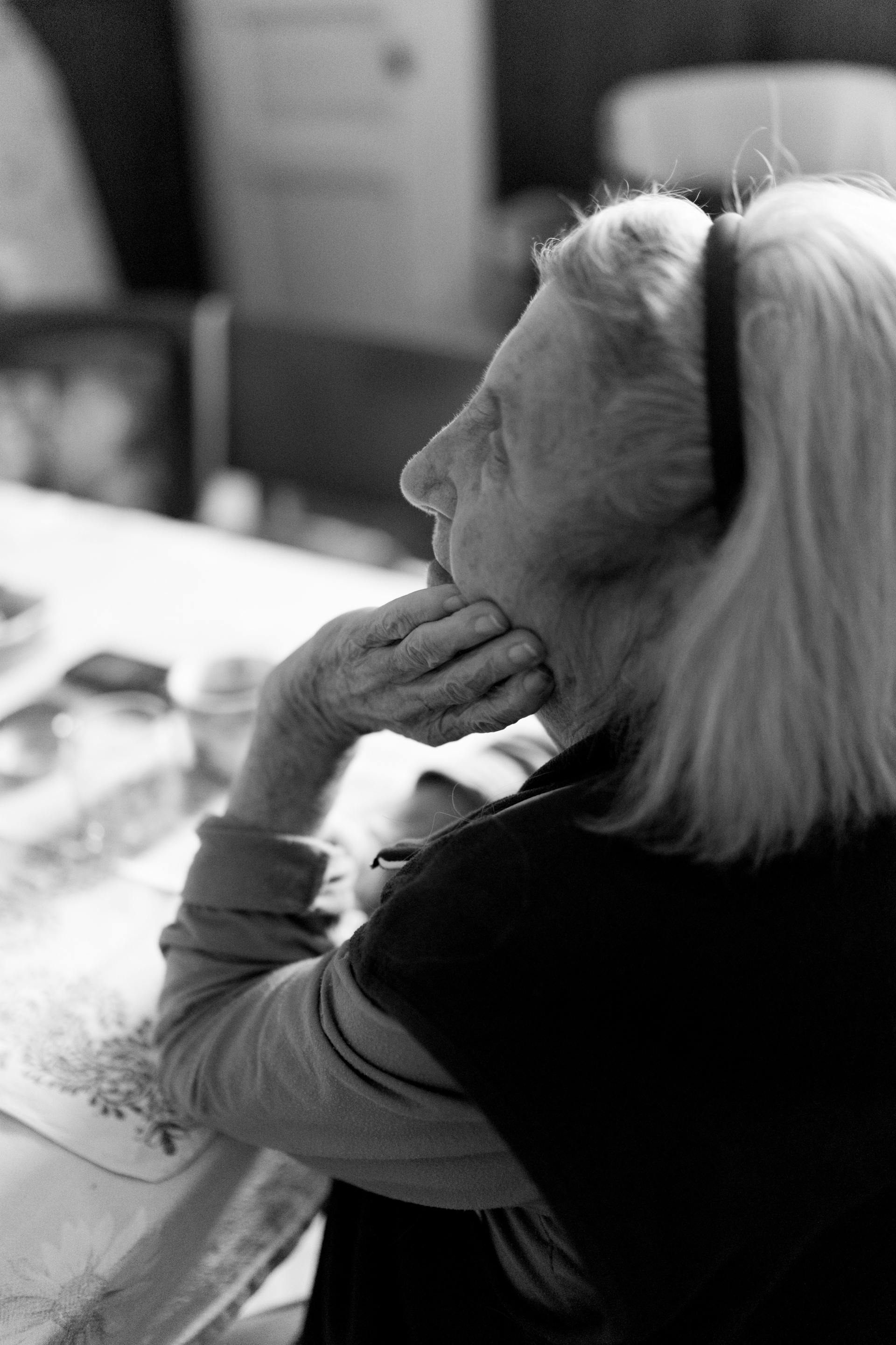 Ein schwarz-weißes Seitenprofilbild einer älteren Frau, die ihr Kinn auf ihre Hand stützt und nach oben schaut: Pexels