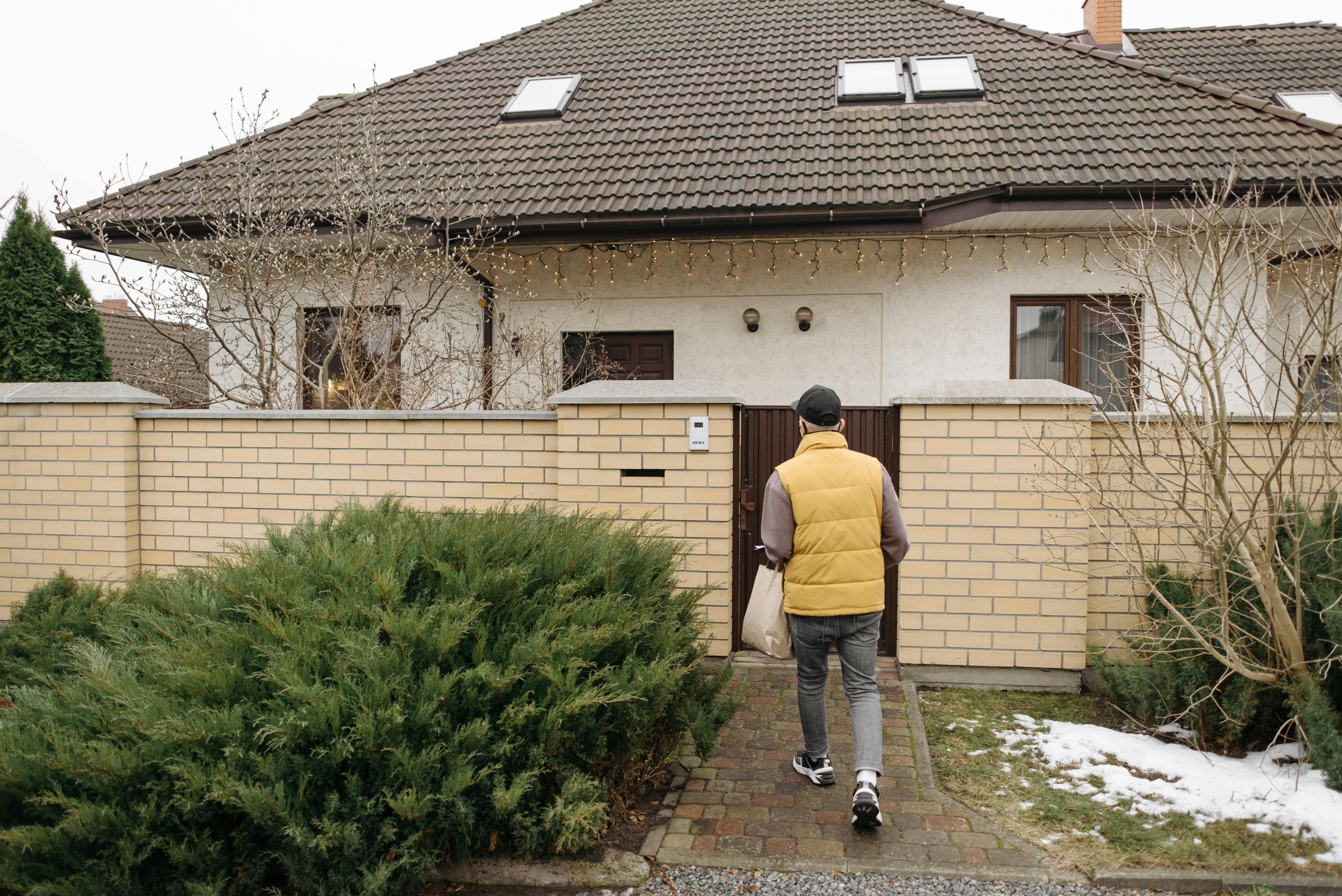 Ein Mann geht auf ein Haus zu | Quelle: Pexels