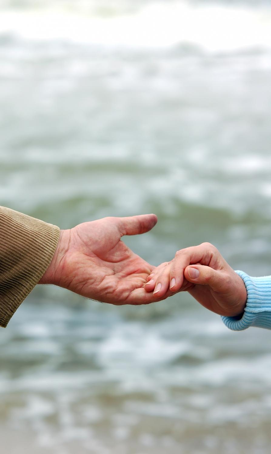 Ein junger und ein älterer Mensch halten sich an den Händen | Quelle: Freepik