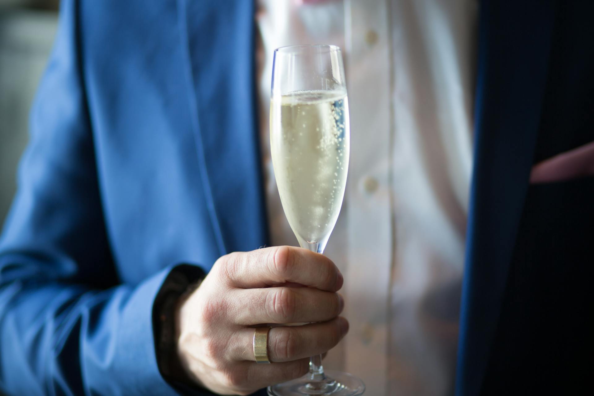 Ausgeschnittene Aufnahme eines Mannes mit einem Glas Champagner | Quelle: Pexels
